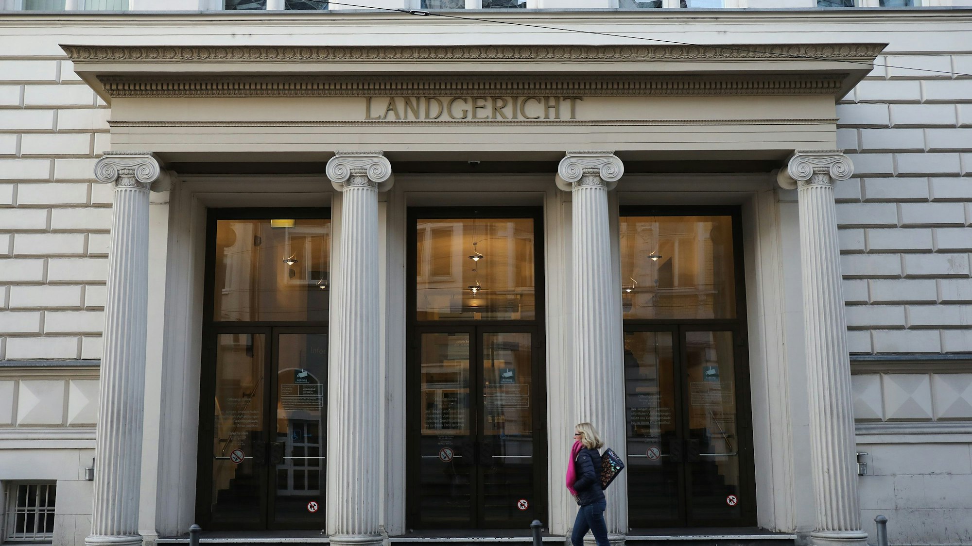 Eine Frau läuft vor dem Eingang des Bonner Landgerichts entlang.