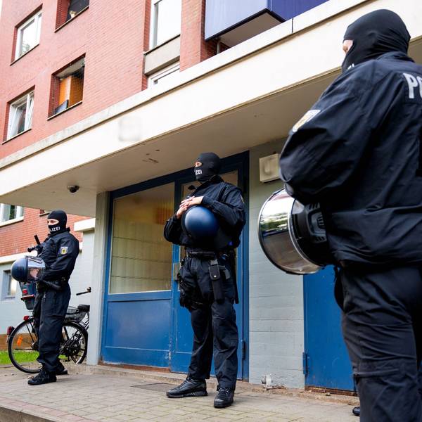 Bundespolizisten sind vor einem Wohnhaus bei einer Razzia im Einsatz.