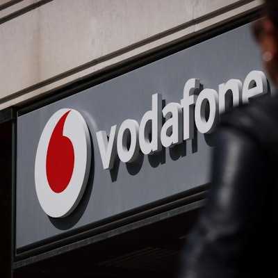 An einem Geschäft hängt ein Schild mit der Aufschrift „Vodafone“.
