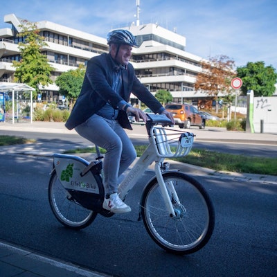 Das Bild zeigt Markus Ramers radelnd vor dem Kreishaus am Jülicher Ring.