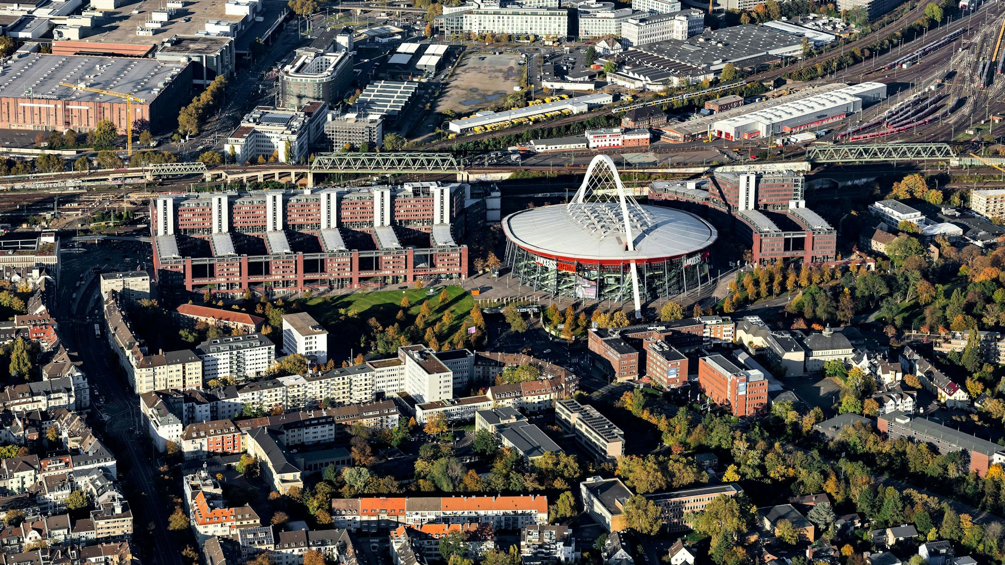 Das Bild zeigt von oben mehrere Gebäude an der Lanxess-Arena und in Deutz.