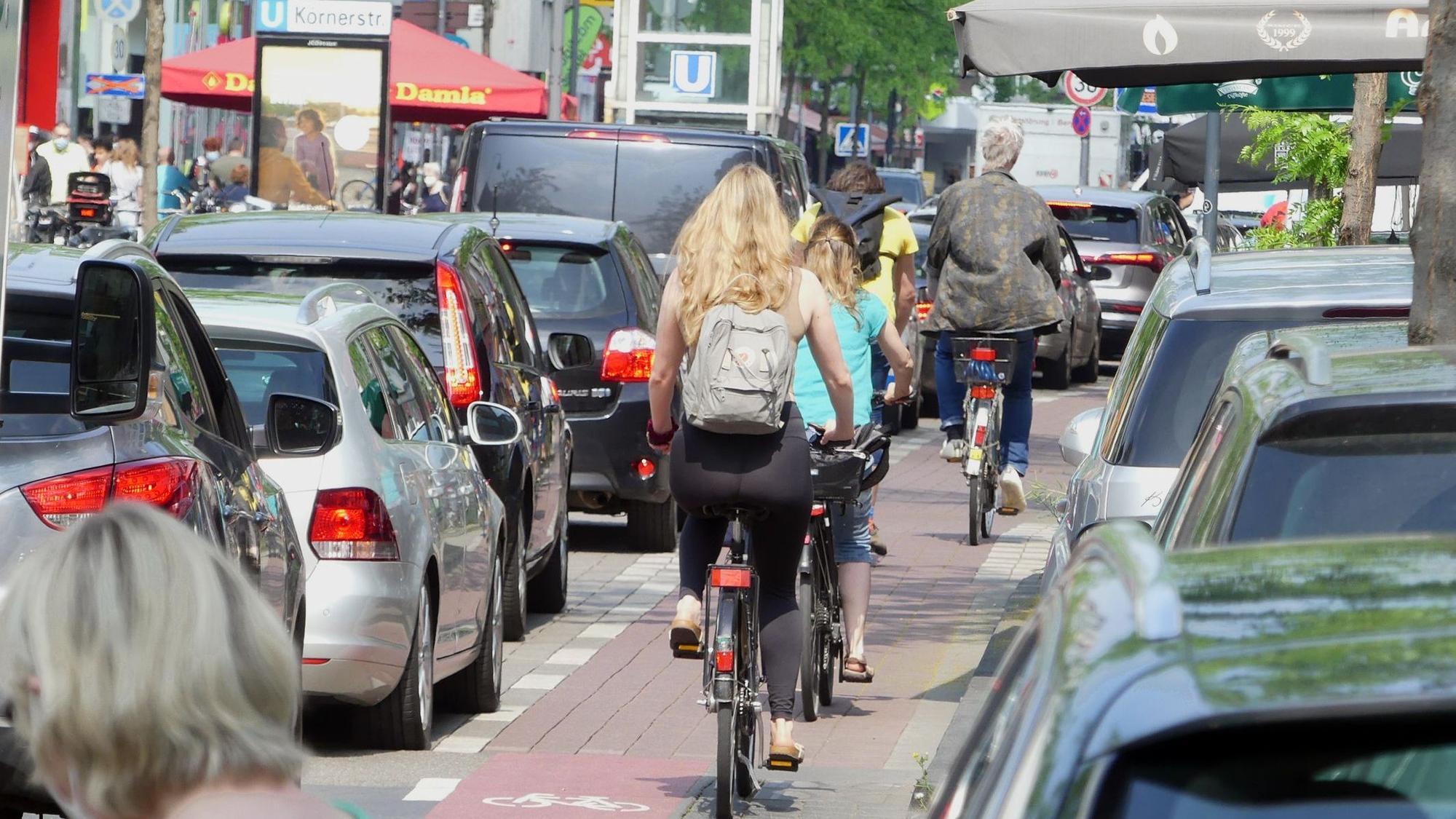Radfahrer und Autofahrer fahren über eine enge Straße.