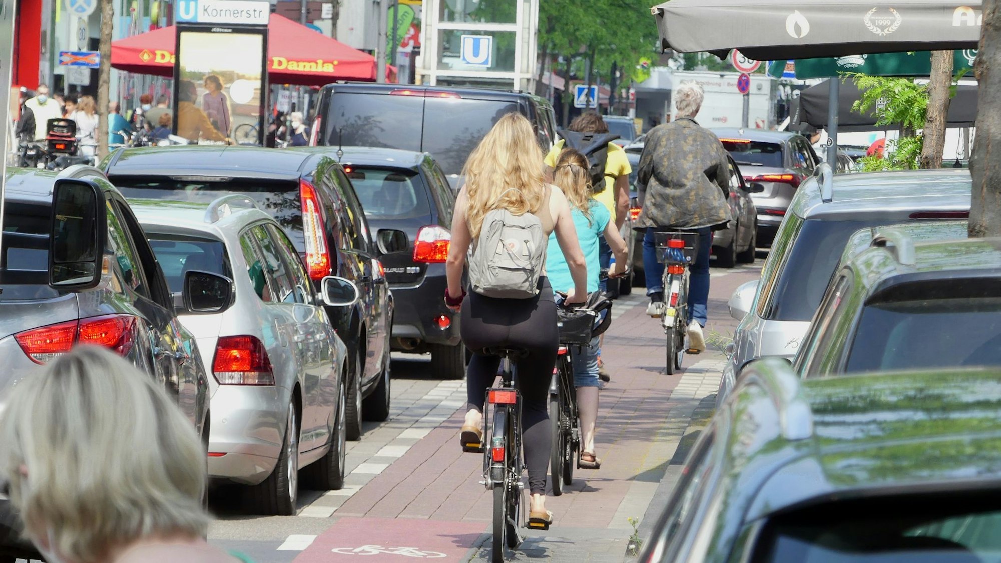 Radfahrer und Autofahrer fahren über eine enge Straße.