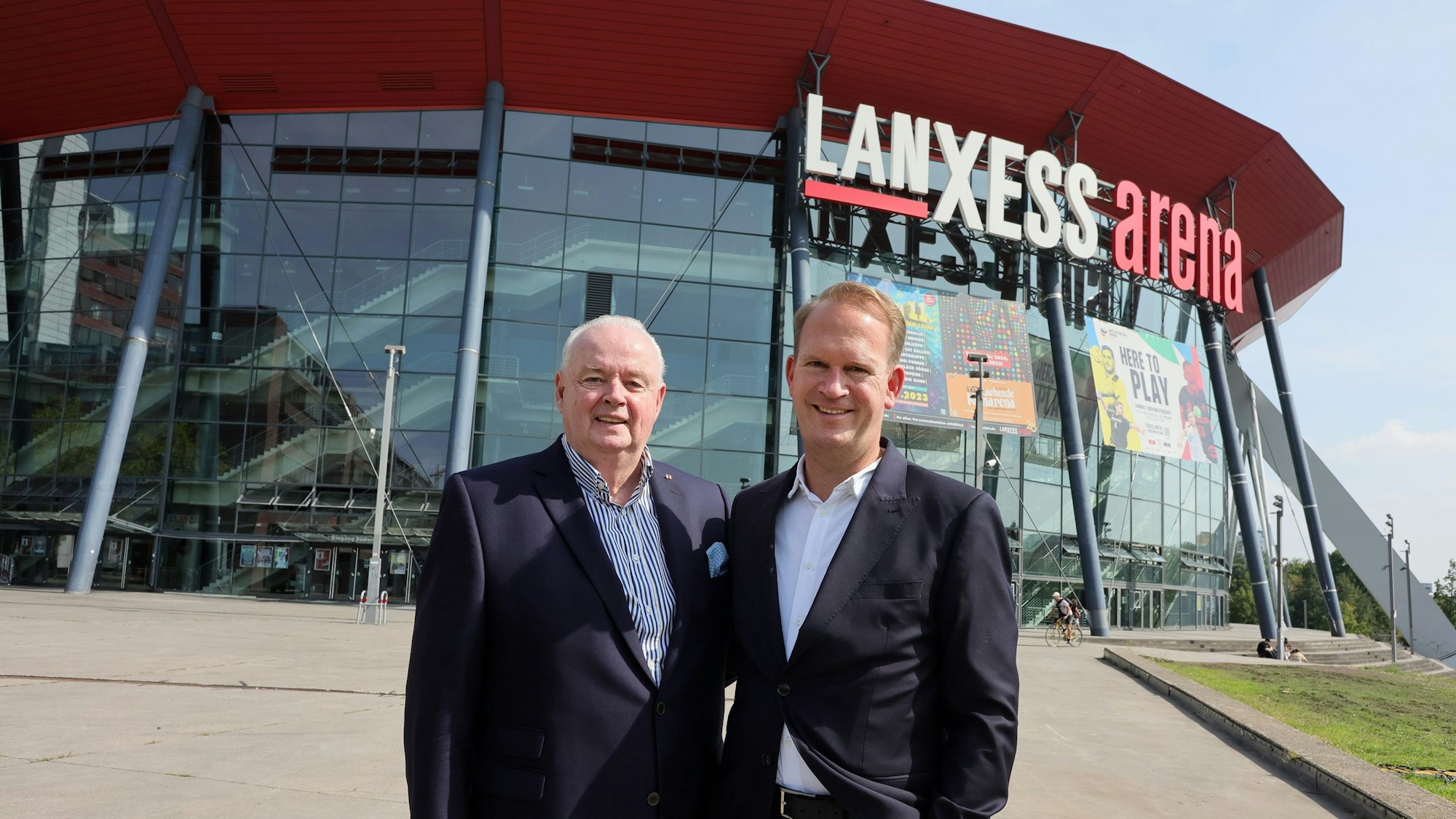 Ralf Bernd Assenmacher und Stefan Löcher stehen vor der Lanxess-Arena.