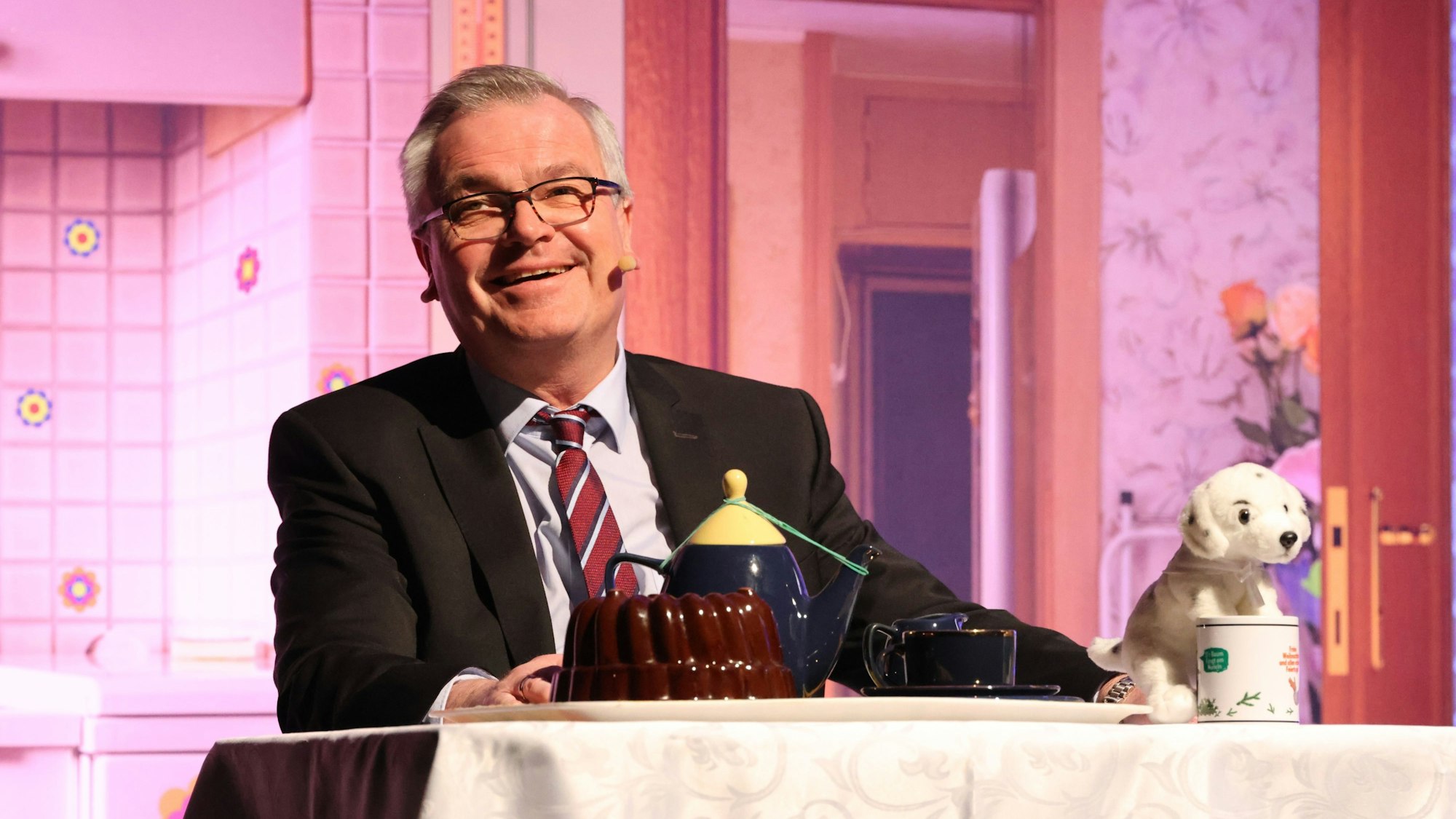 Kabarettist Jürgen B. Hausmann sitzt an einem Tisch.