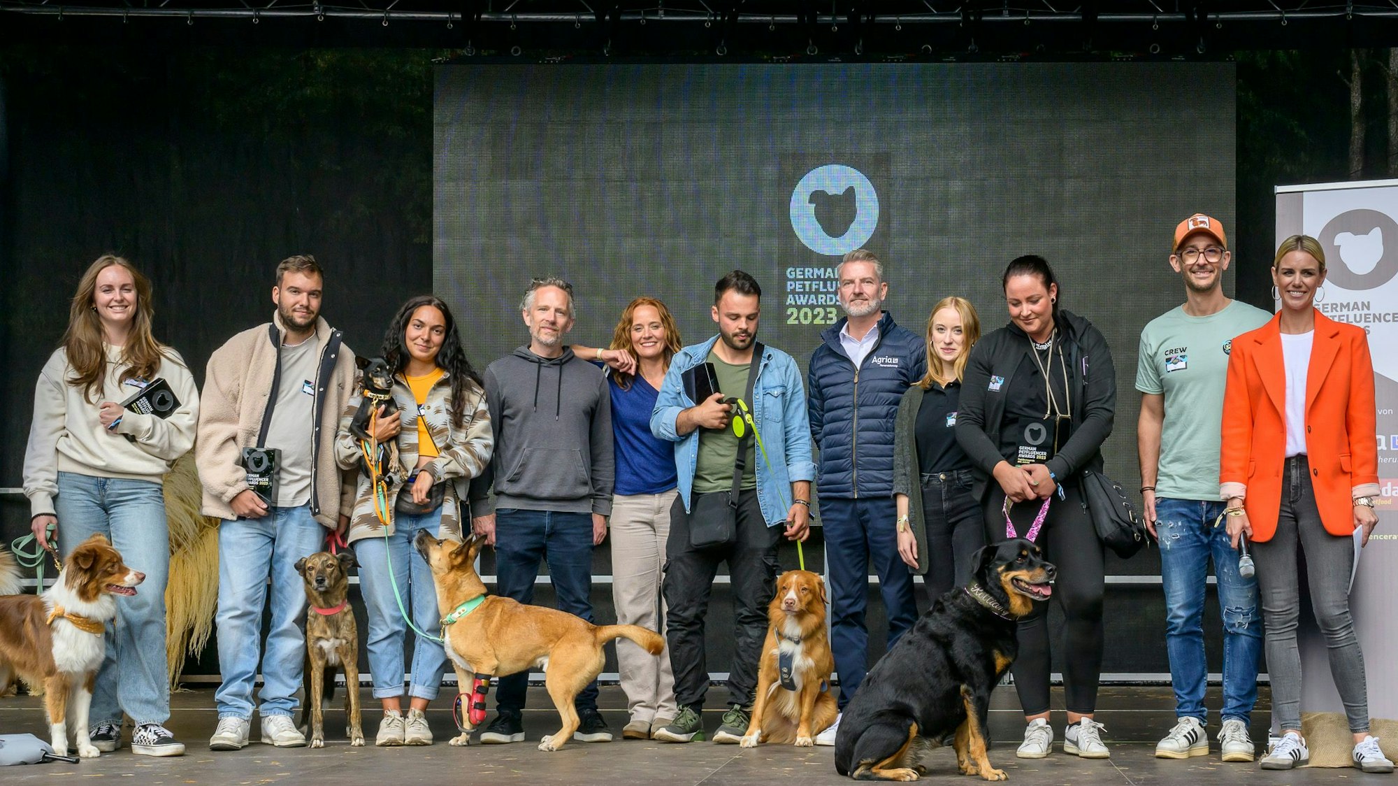 Die Gewinner stehen mit ihren Hunden auf der Bühne.