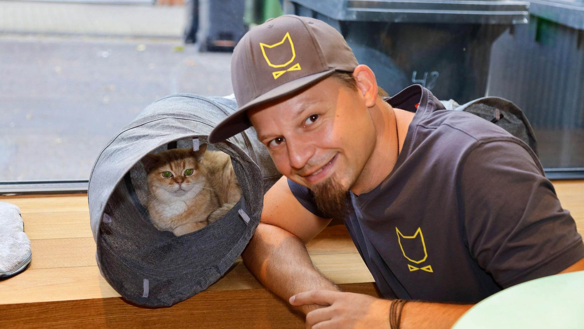 Michael Guddat, Tierpsychologe, Katzensitter und Katzenexperte, mit einer Katze im Café Katzentempel in der Kölner Severinstrasse.