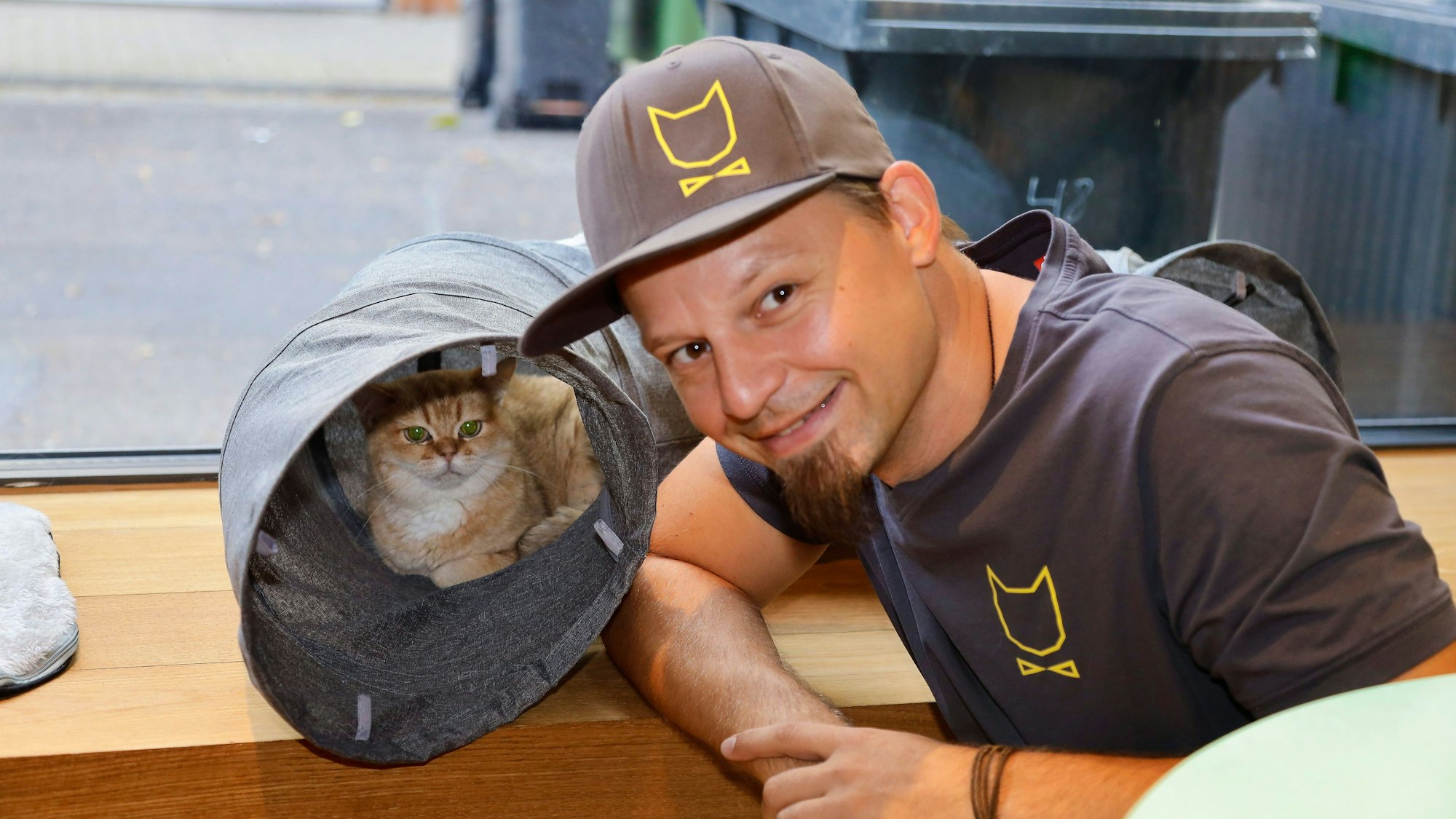 Michael Guddat, Tierpsychologe, Katzensitter und Katzenexperte, mit einer Katze im Café Katzentempel in der Kölner Severinstrasse.