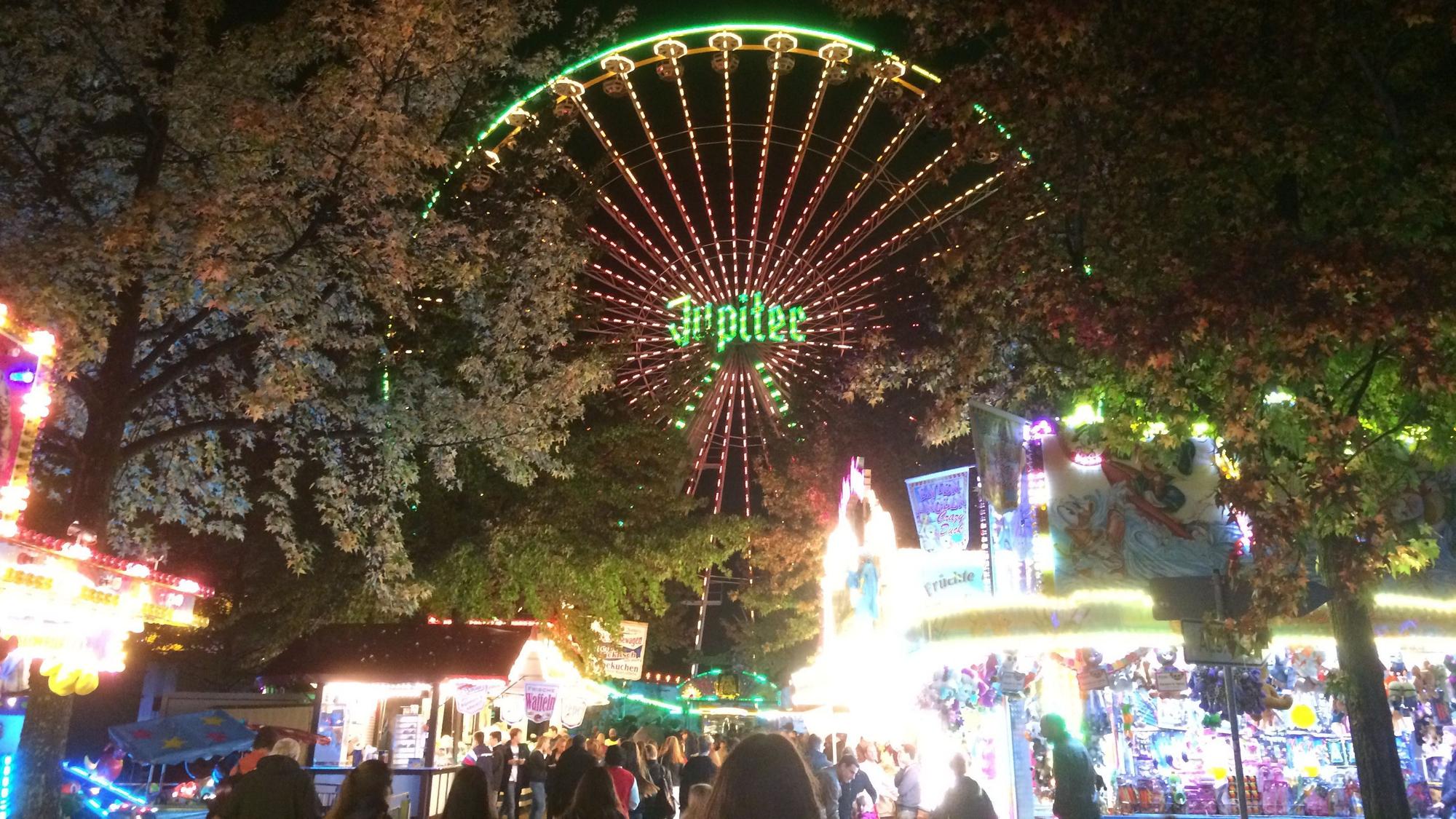 Ein Riesenrad leuchtet über die Büdchen auf der Kirmes in Junkersdorf hinweg. (Archivbild)