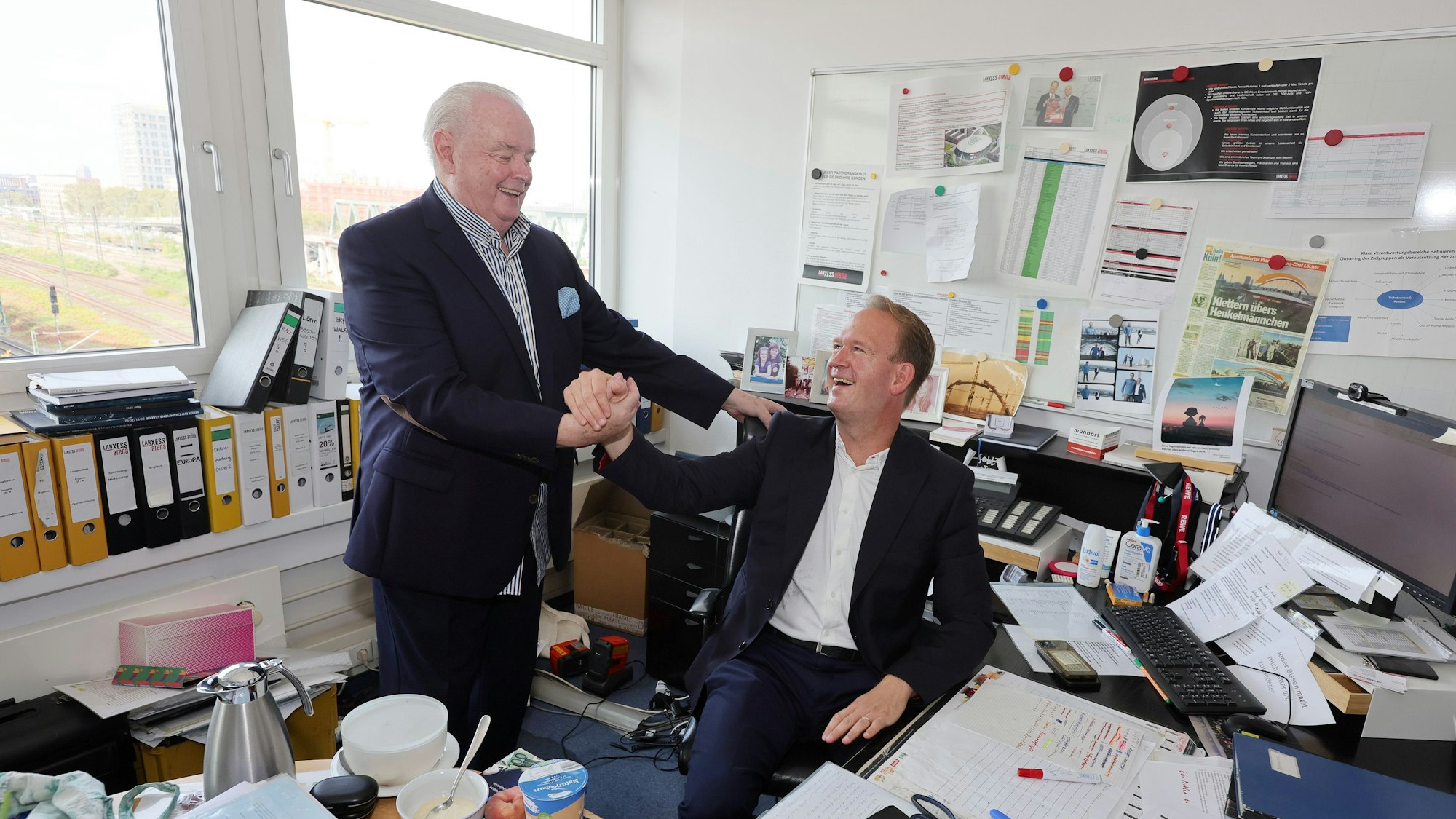 Ralf Bernd Assenmacher und Stefan Löcher geben sich im Büro die Hand.