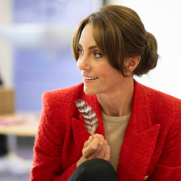 Die Prinzessin von Wales hält eine Feder in der Hand und blickt zur Seite.