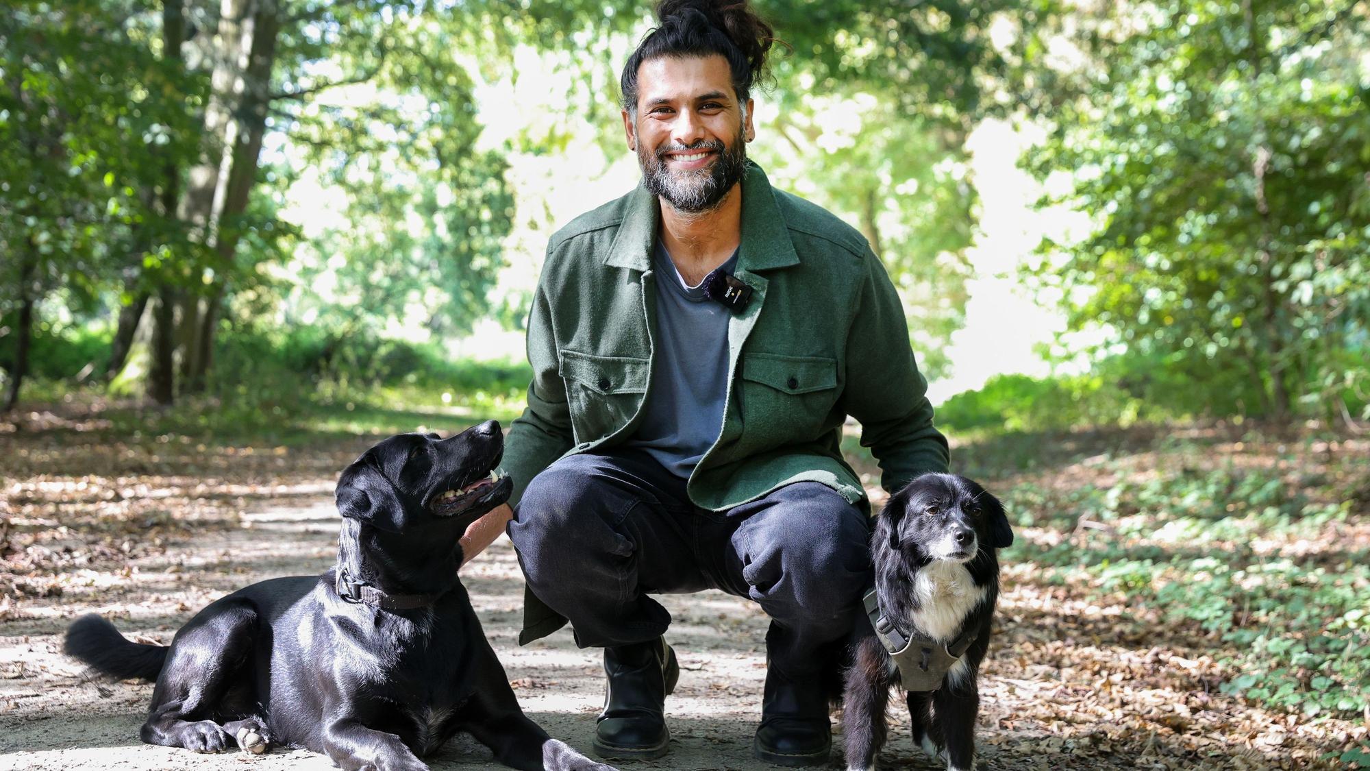 Hunde-Verhaltenstherapeut Masih Samin mit zwei hHunden im Wald.