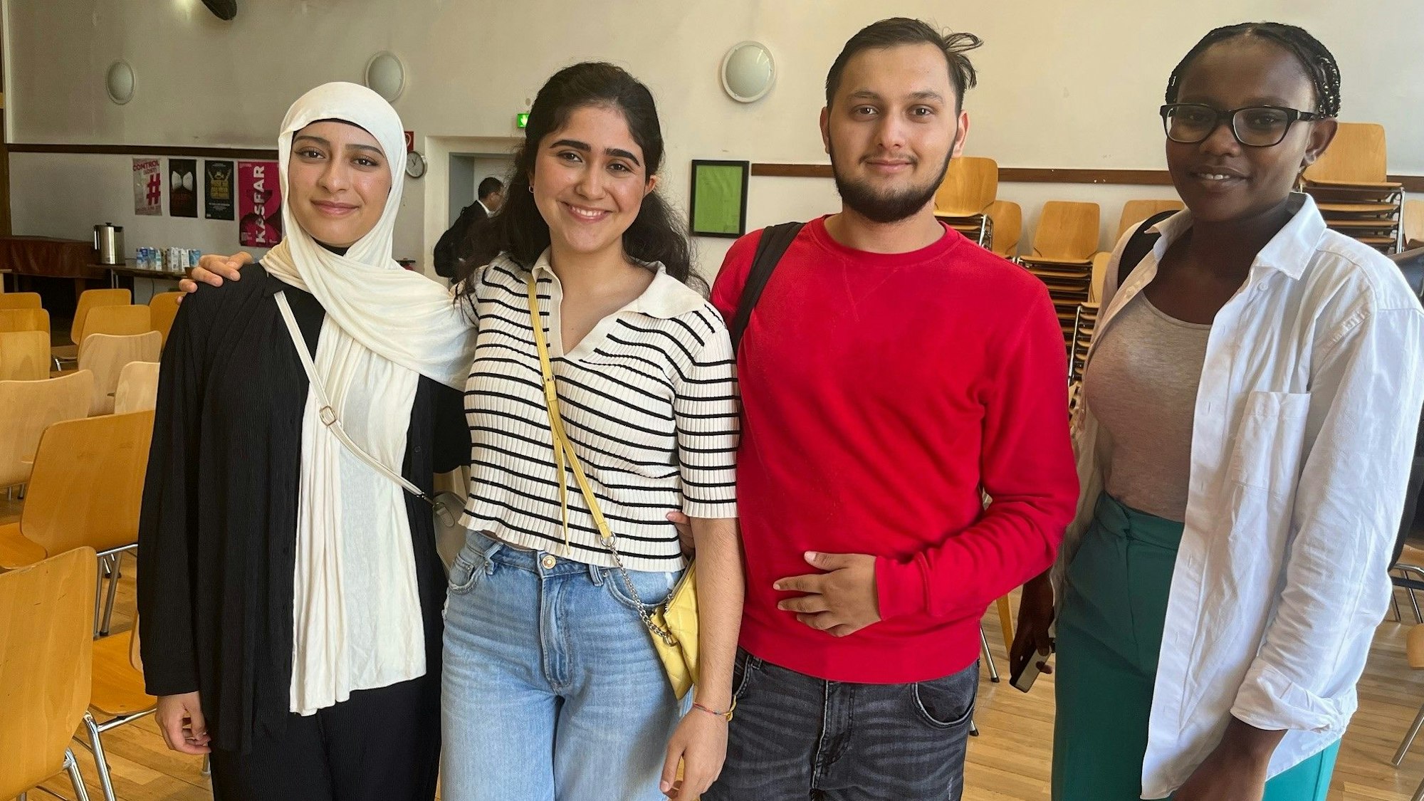Vier Schülerinnen und Schüler posieren im Genoveva-Gymnasium Köln-Mülheim.