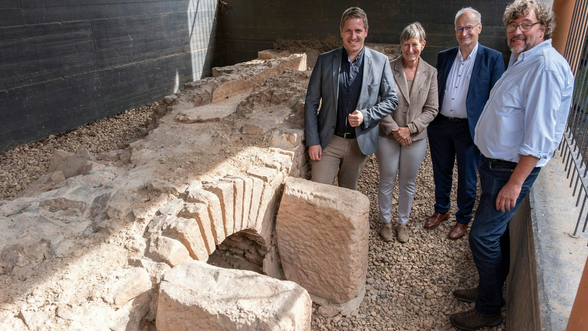 Steinrestaurator Thomas Sieverding (r.), Landrat Markus Ramers (v.l.), Petra Tutlies (LVR) und Mechernichs Bürgermeister Dr. Hans-Peter Schick an den Resten der römischen Aquäduktbrücke bei Mechernich-Vollem.