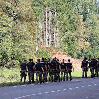 Französische Gendarmen laufen auf der Suche nach der verschwundenen Lina durch ein Waldstück.