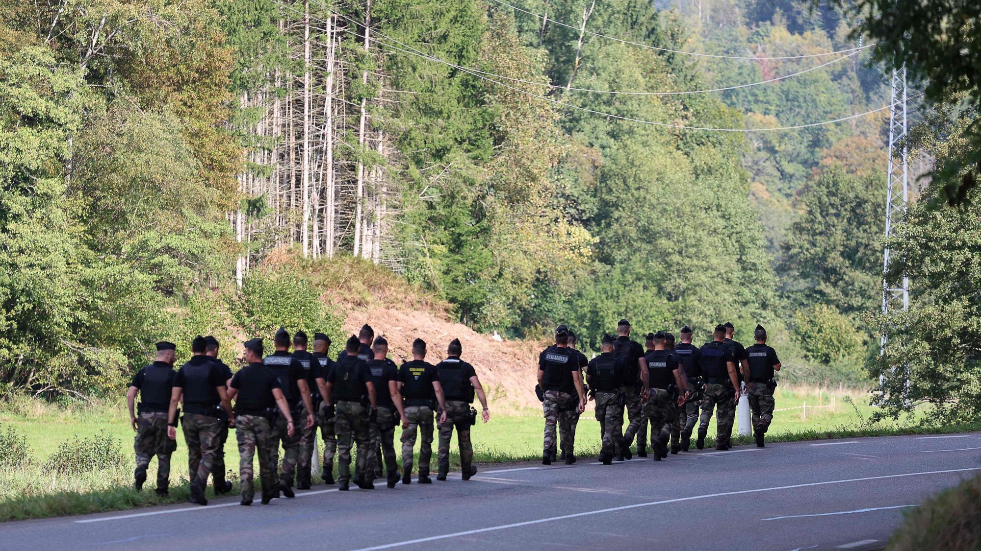Französische Gendarmen laufen auf der Suche nach der verschwundenen Lina durch ein Waldstück.