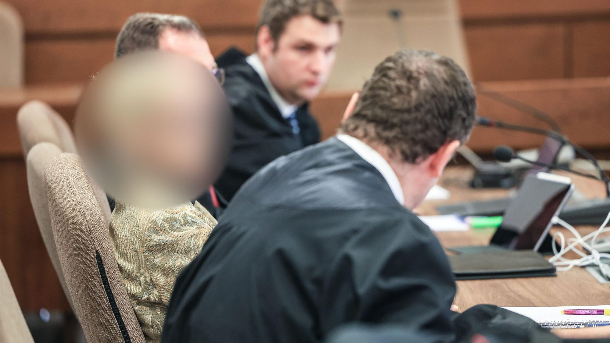 Eine Apothekerin (l) sitzt im Landgericht zwischen ihren Anwälten auf der Anklagebank.