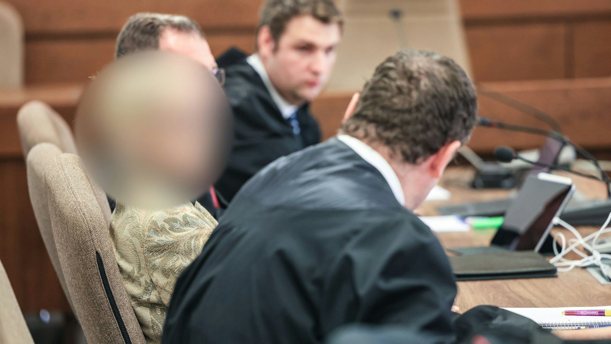 Eine Apothekerin (l) sitzt im Landgericht zwischen ihren Anwälten auf der Anklagebank.