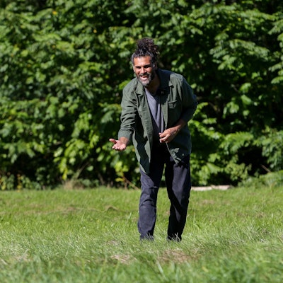 Hunde-Verhaltenstherapeut Masih Samin steht auf einer Wiese und ruft seine Hündin Thea zu sich.