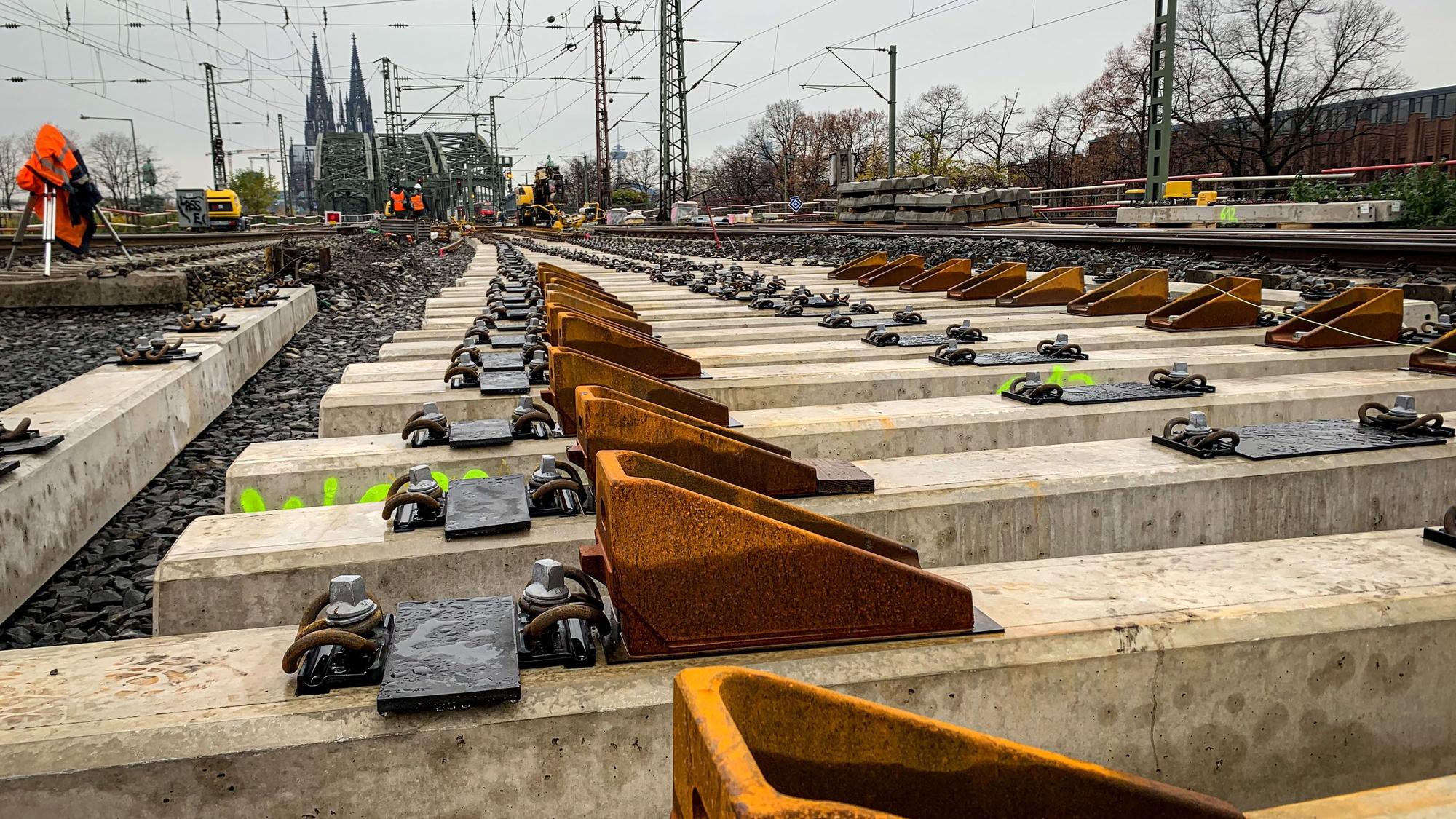 Bahngleise im Vordergrund, im Hintergrund ist der Kölner Dom zu sehen.