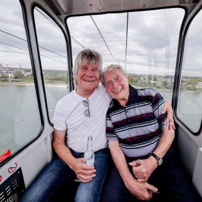 „Bläck Fööss“-Gründungsmitglied Bömmel Lückerath und Sänger Ludwig Sebus fahren nach dem Pressetermin zur Vorstellung des Songs mit der Seilbahn.