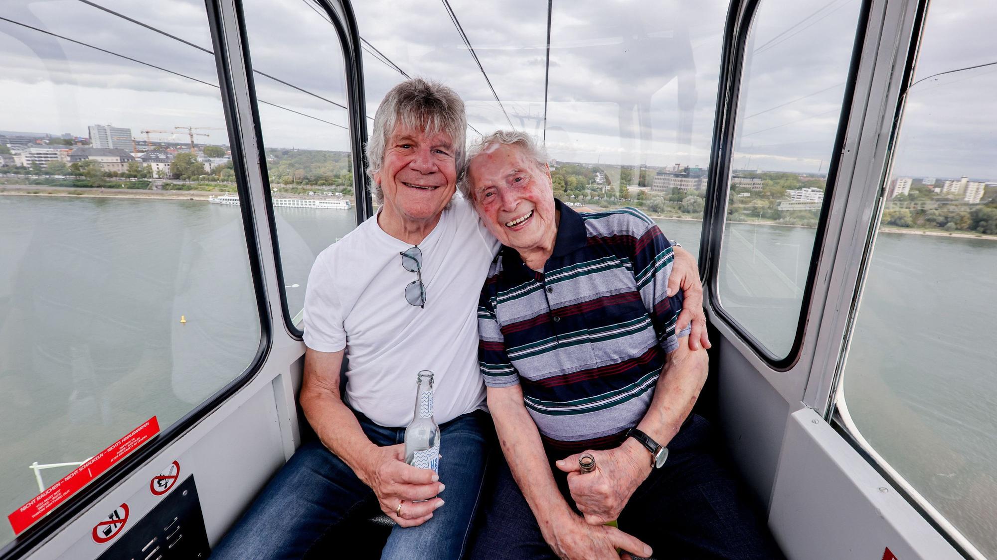 „Bläck Fööss“-Gründungsmitglied Bömmel Lückerath und Sänger Ludwig Sebus fahren nach dem Pressetermin zur Vorstellung des Songs mit der Seilbahn.