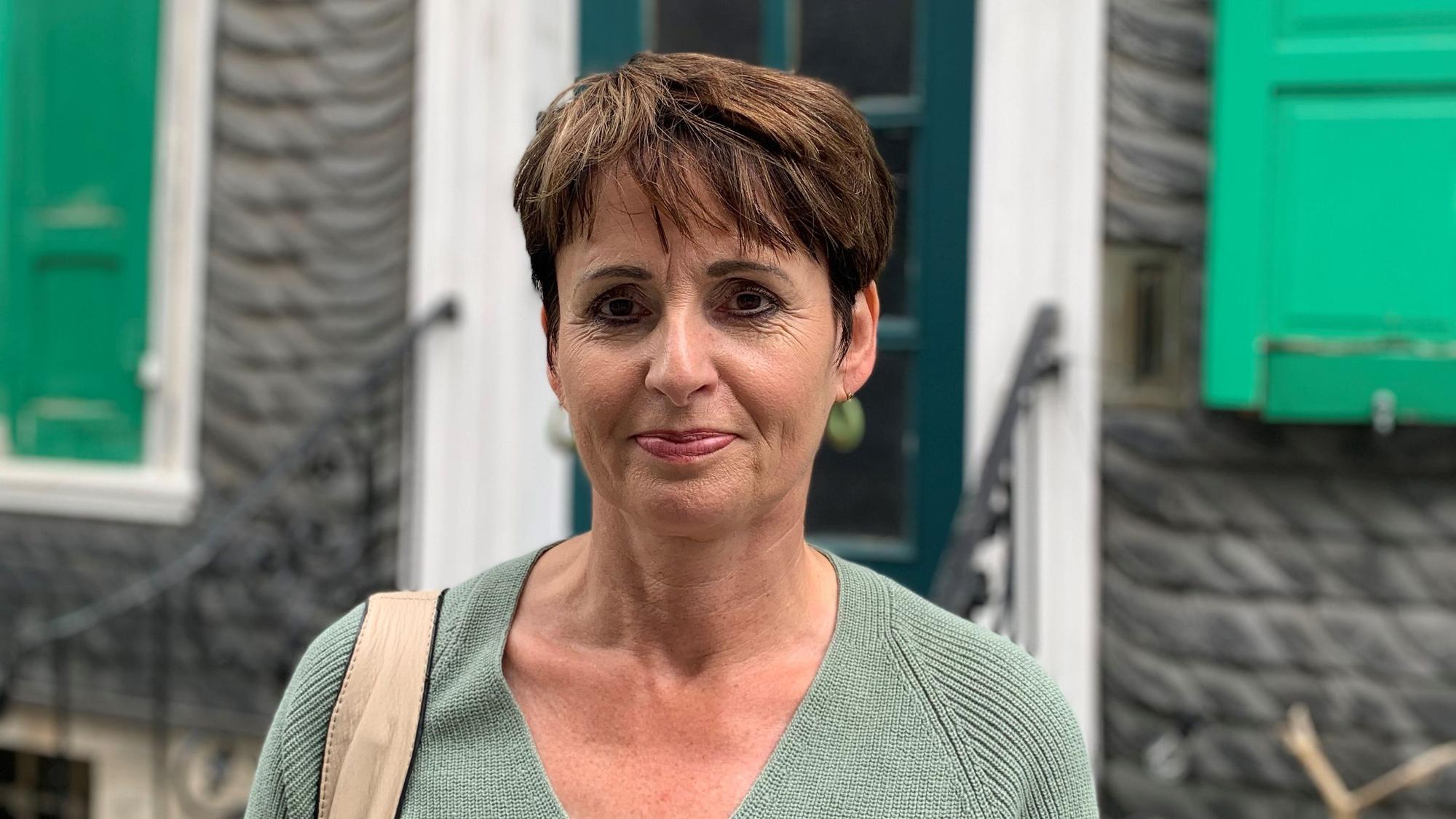 Anja Hamm vom Stadtmarketing Remscheid steht vor einem Lenneper Schieferhaus.
