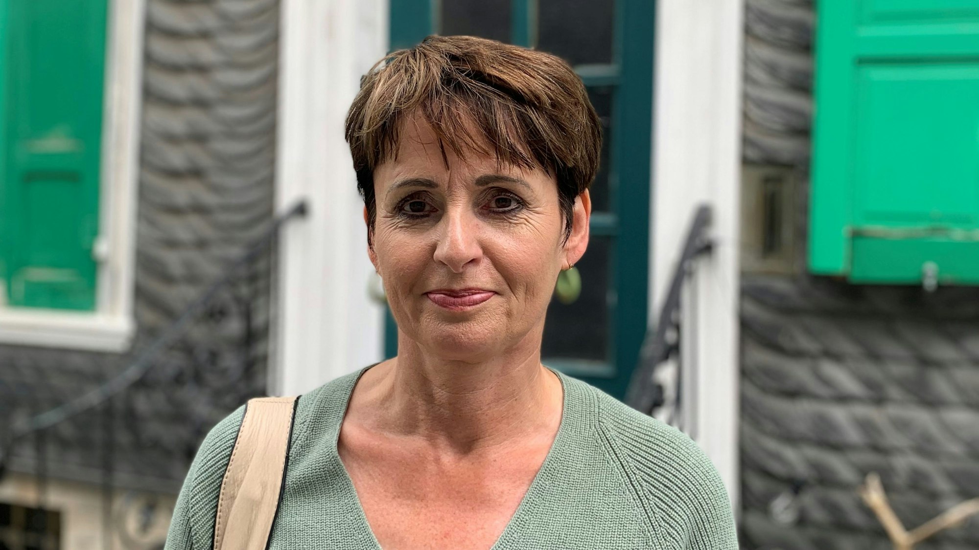 Anja Hamm vom Stadtmarketing Remscheid steht vor einem Lenneper Schieferhaus.
