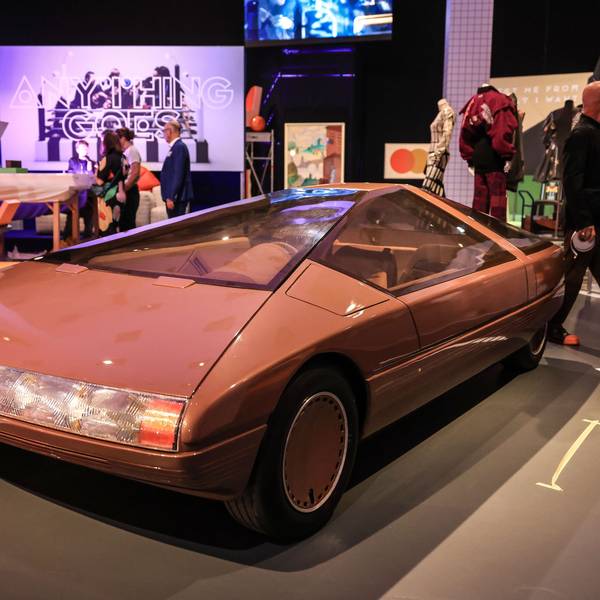 Das Konzeptfahrzeug "Citroen Karin" aus dem Jahr 1980 steht in der Bundeskunsthalle. Es ist rötlich und geometrisch-schnittig. Im Hintergrund weitere bunte Kunstwerke und Besucher.