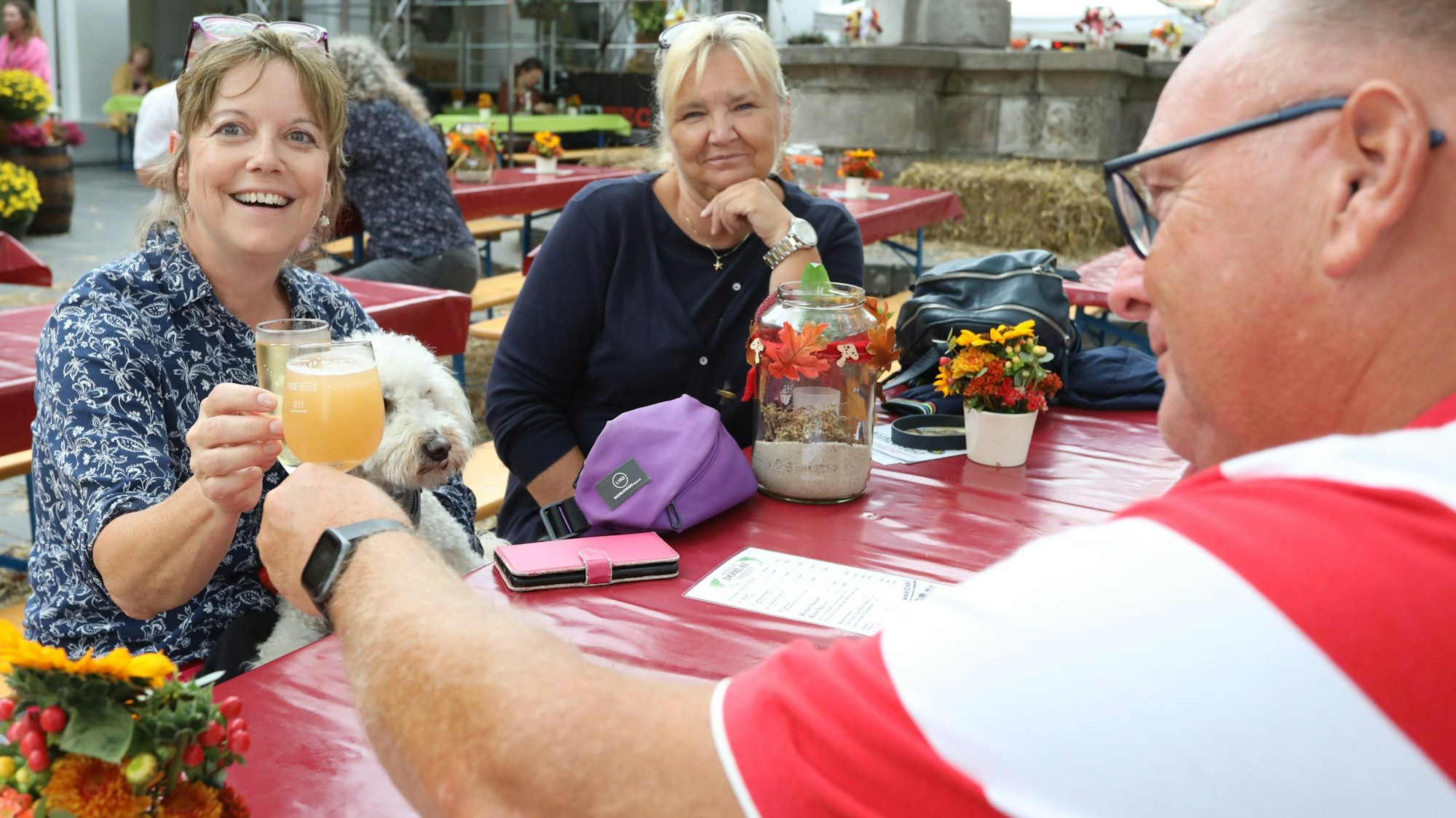 Eine Frau und ein Mann stoßen mit Saft- beziehungsweise Weingläsern an.