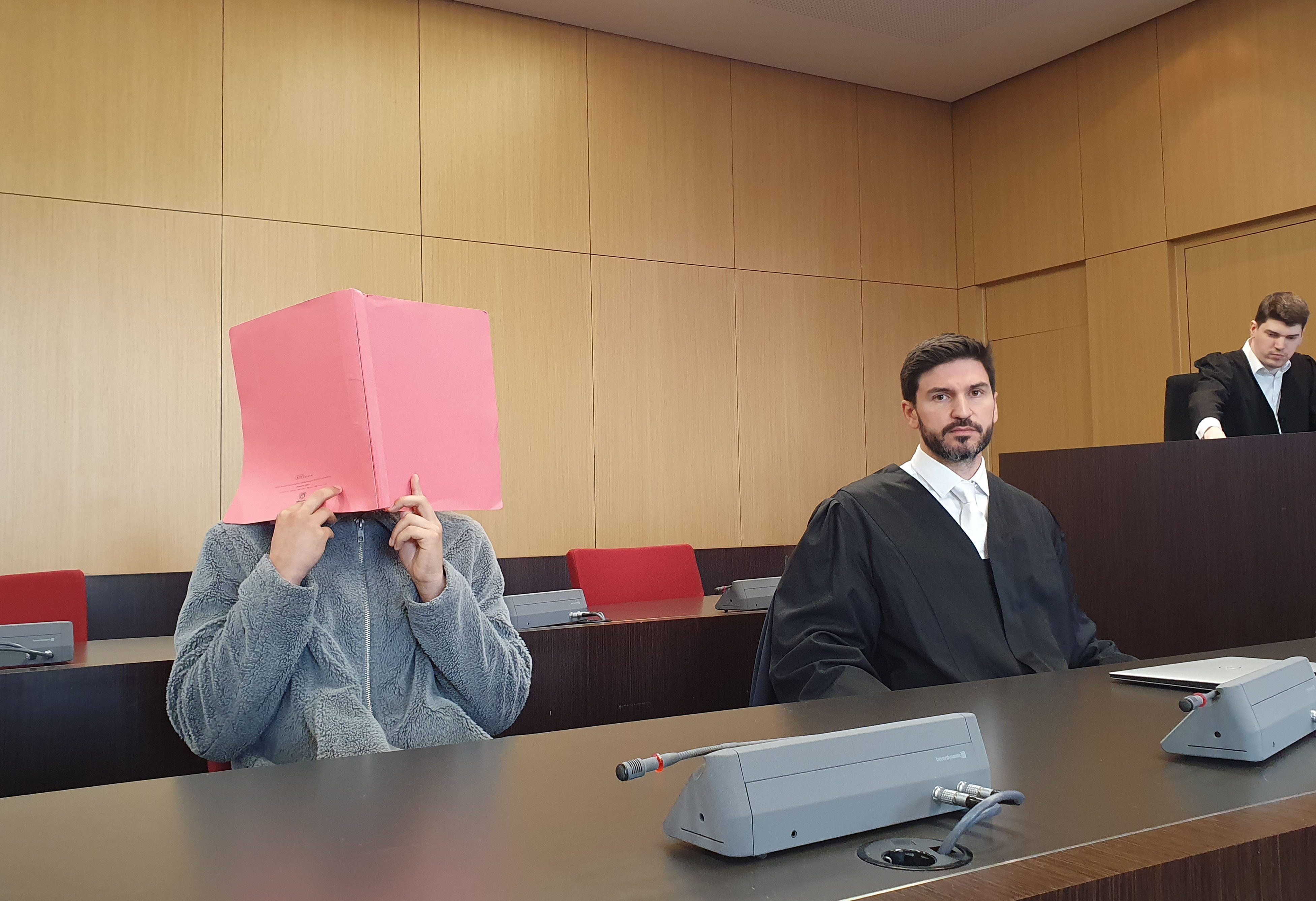 Der Angeklagte (l) sitzt neben seinem Verteidiger Heiko Löw auf der Anklagebank in einem Saal des Düssseldorfer Landgerichts. Er soll in der Düsseldorfer Altstadt einen 47-Jährigen mit einem wuchtigen Tritt getötet haben.
