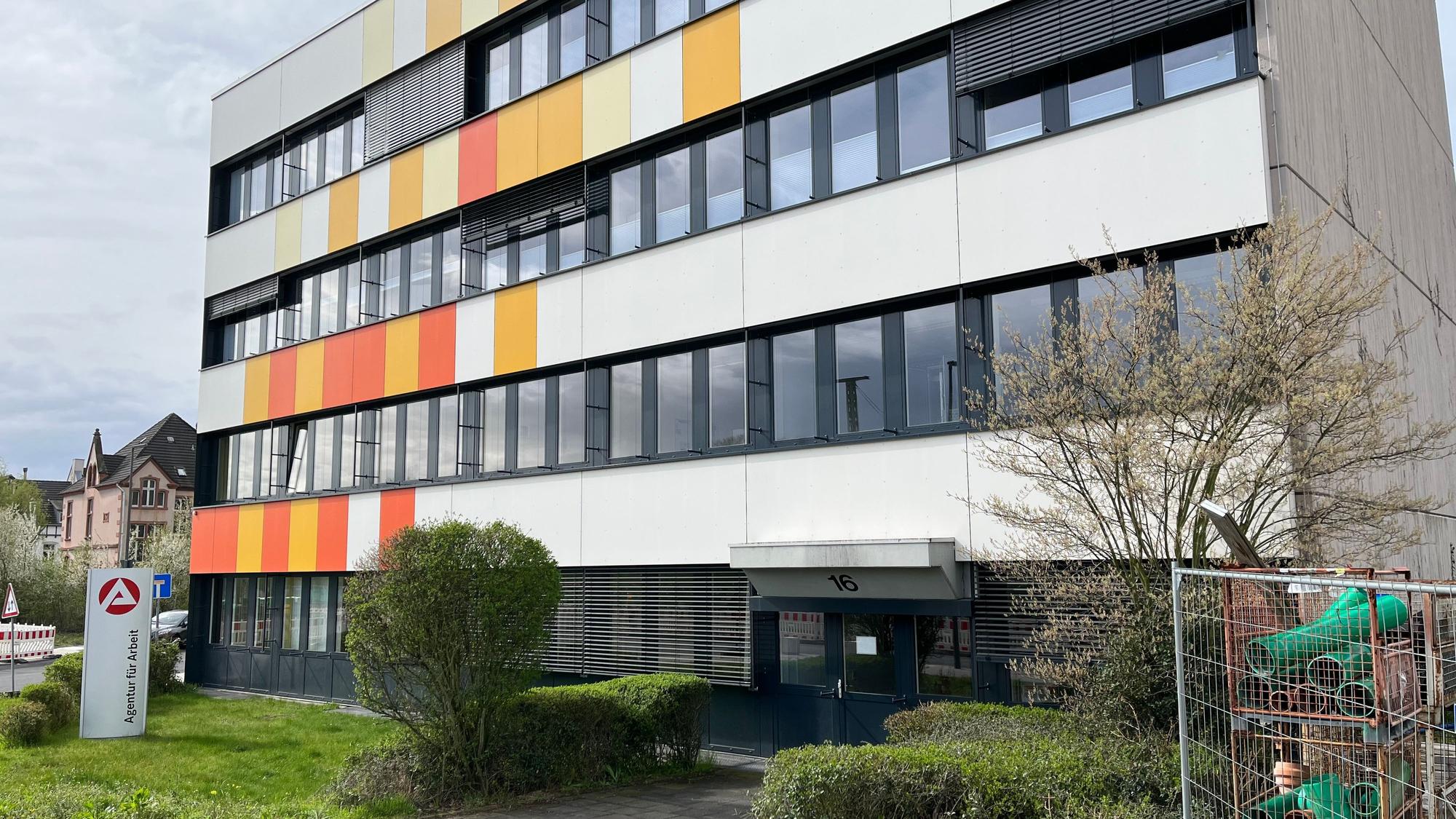 Ein rechteckiges Gebäude mit weiß, gelber und oranger Fassade.