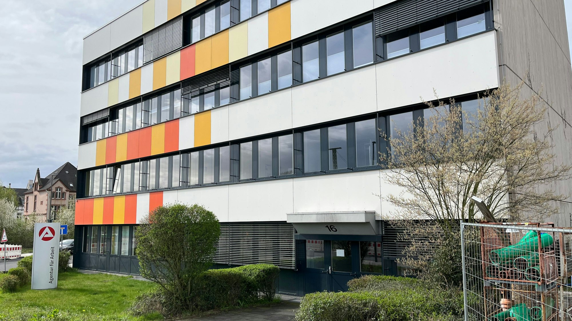 Ein rechteckiges Gebäude mit weiß, gelber und oranger Fassade.