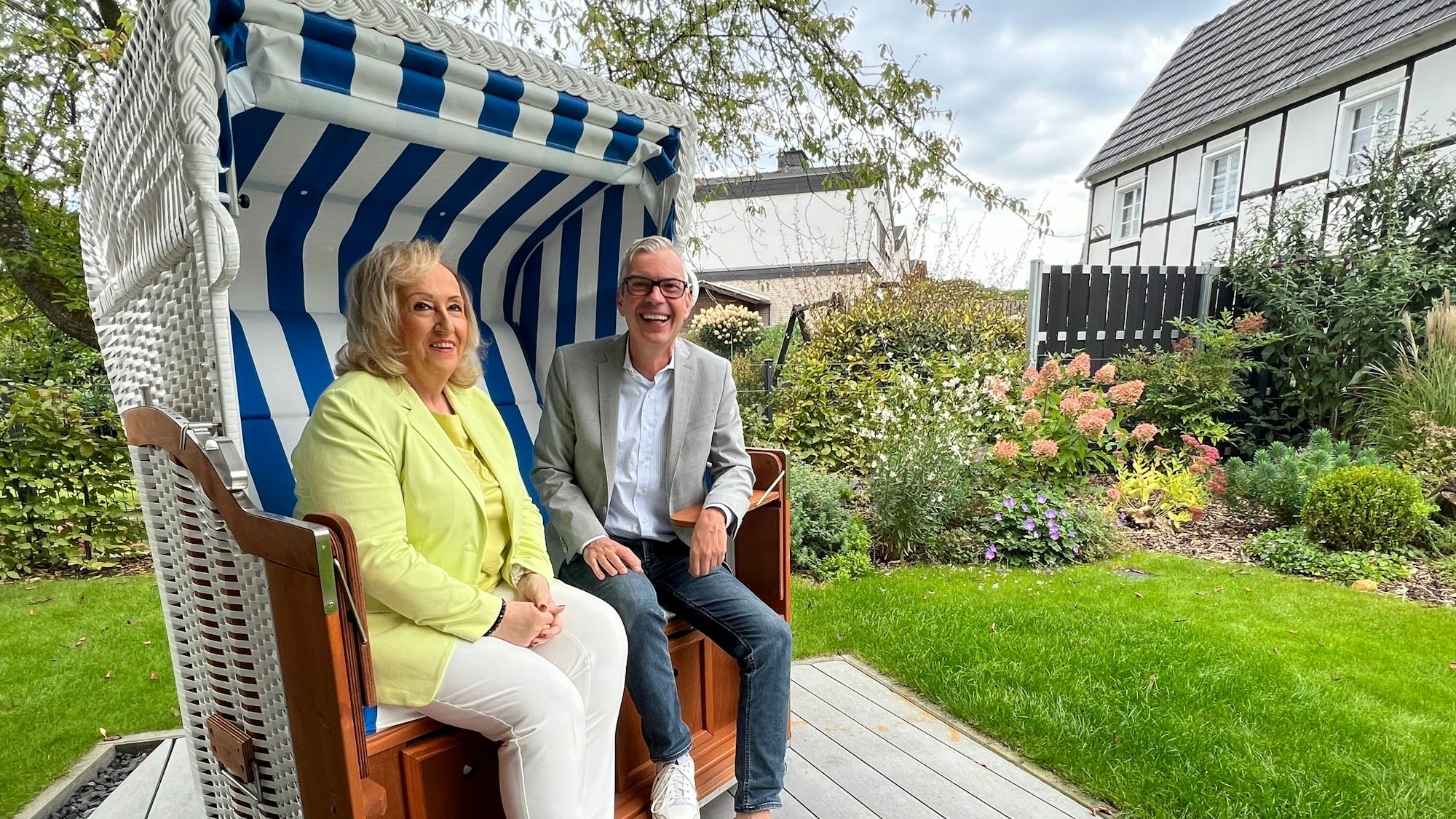 Marianne Müller, 2. Vorsitzende des Fördervereins Palli-Lev, sitzt mit Dierk Hedwig, Sprecher Sparkasse Leverkusen, in einem Strandkorb.