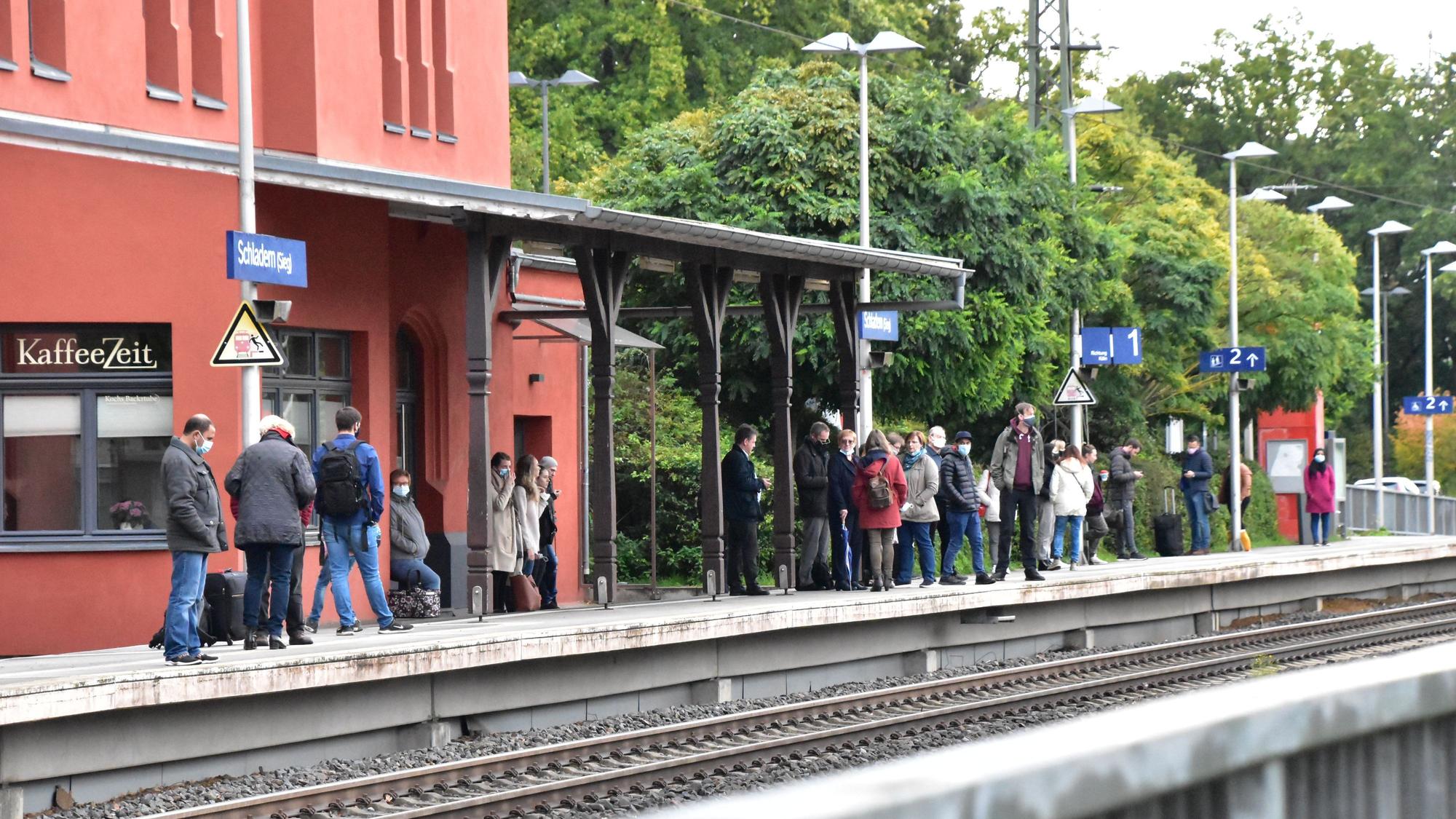 Reisende warten auf einem Bahnsteig auf den Zug.