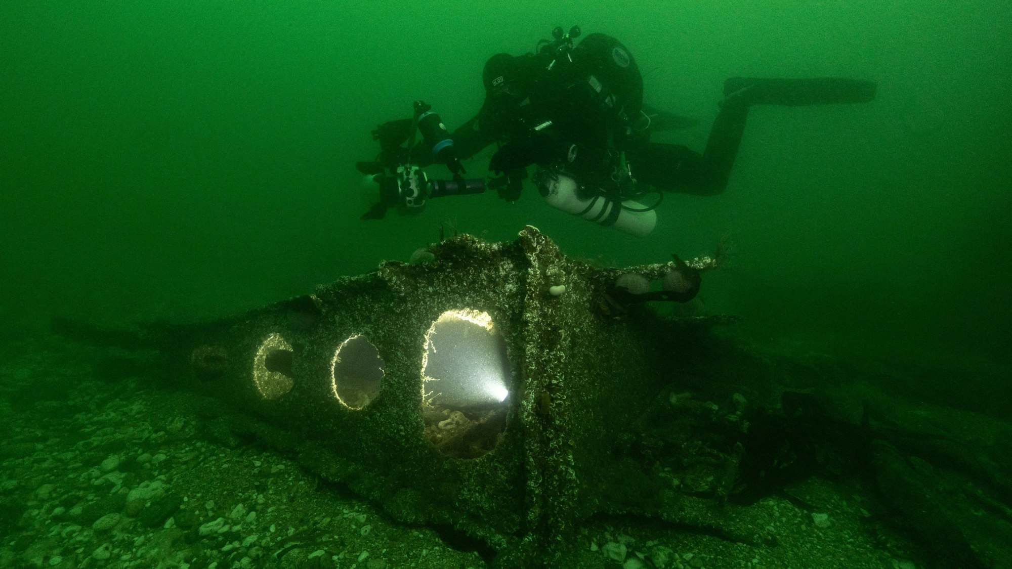 Ein Forscher taucht in der Nordsee vor einem Wrackteil des 1919 vor Helgoland gesunkenen U-Boots.