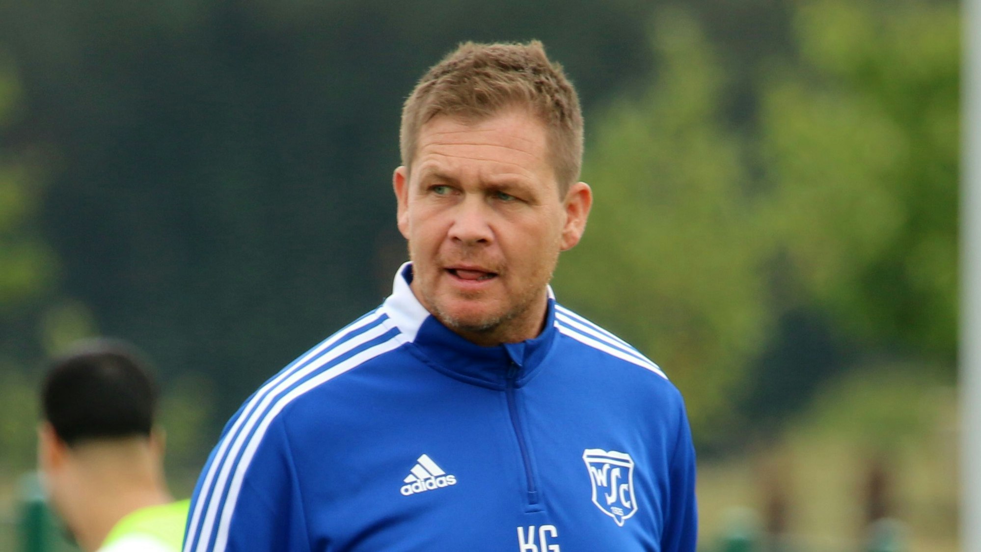 Das Bild zeigt einen Mann im Trainingsanzug.