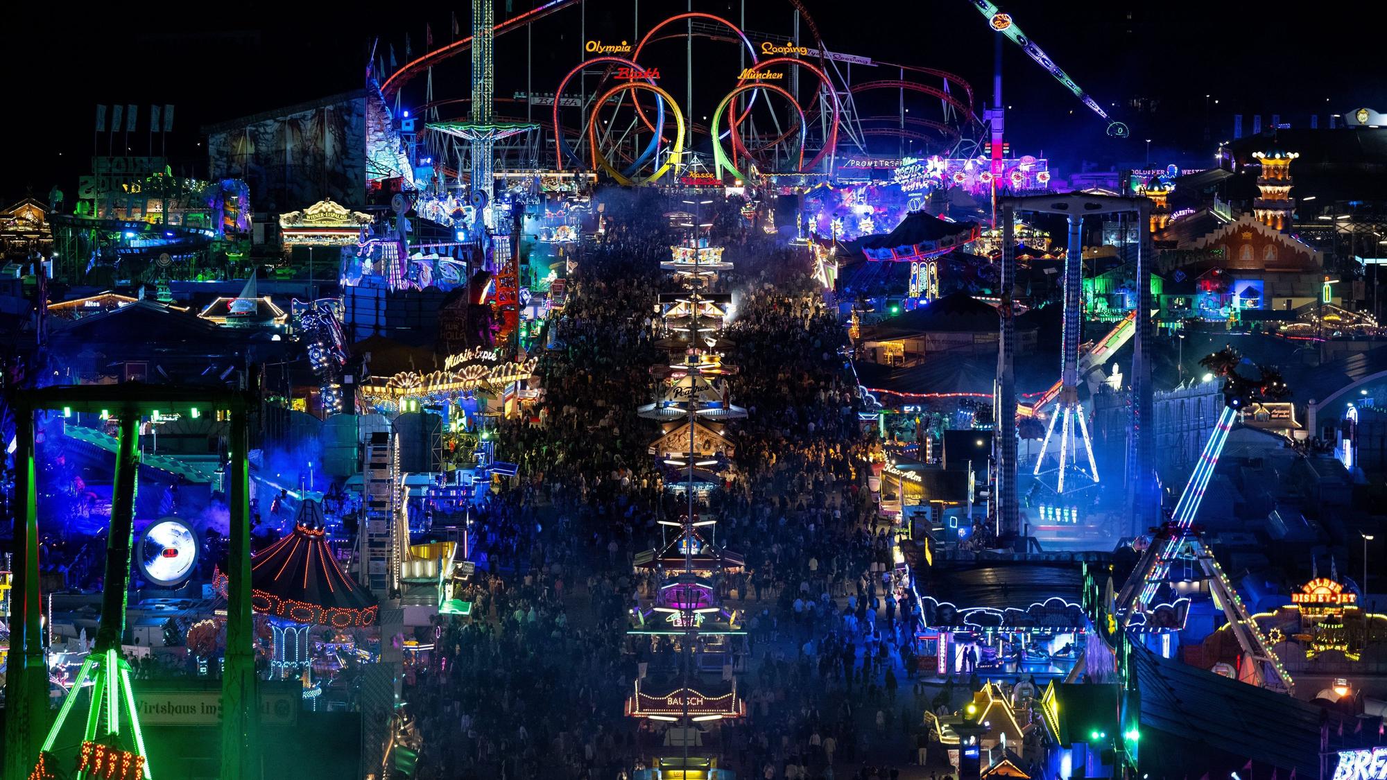 Zahlreiche Menschen laufen zwischen den Fahrgeschäften über das Festgelände. Die 188. Wiesn findet dieses Jahr vom 16.09.- 03.10.2023 statt. (Symbolbild)