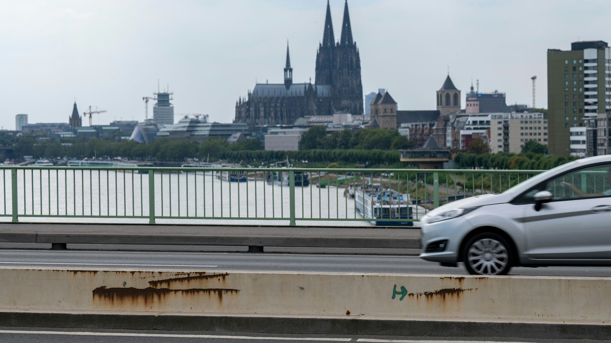 Ein Auto fährt über die Zoobrücke in Köln, im Hintergrund ist der Kölner Dom zu sehen.