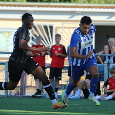 Das Bild zeigt den Fußballer Deniz Isitmen im Laufduell mit einem Gegenspieler.