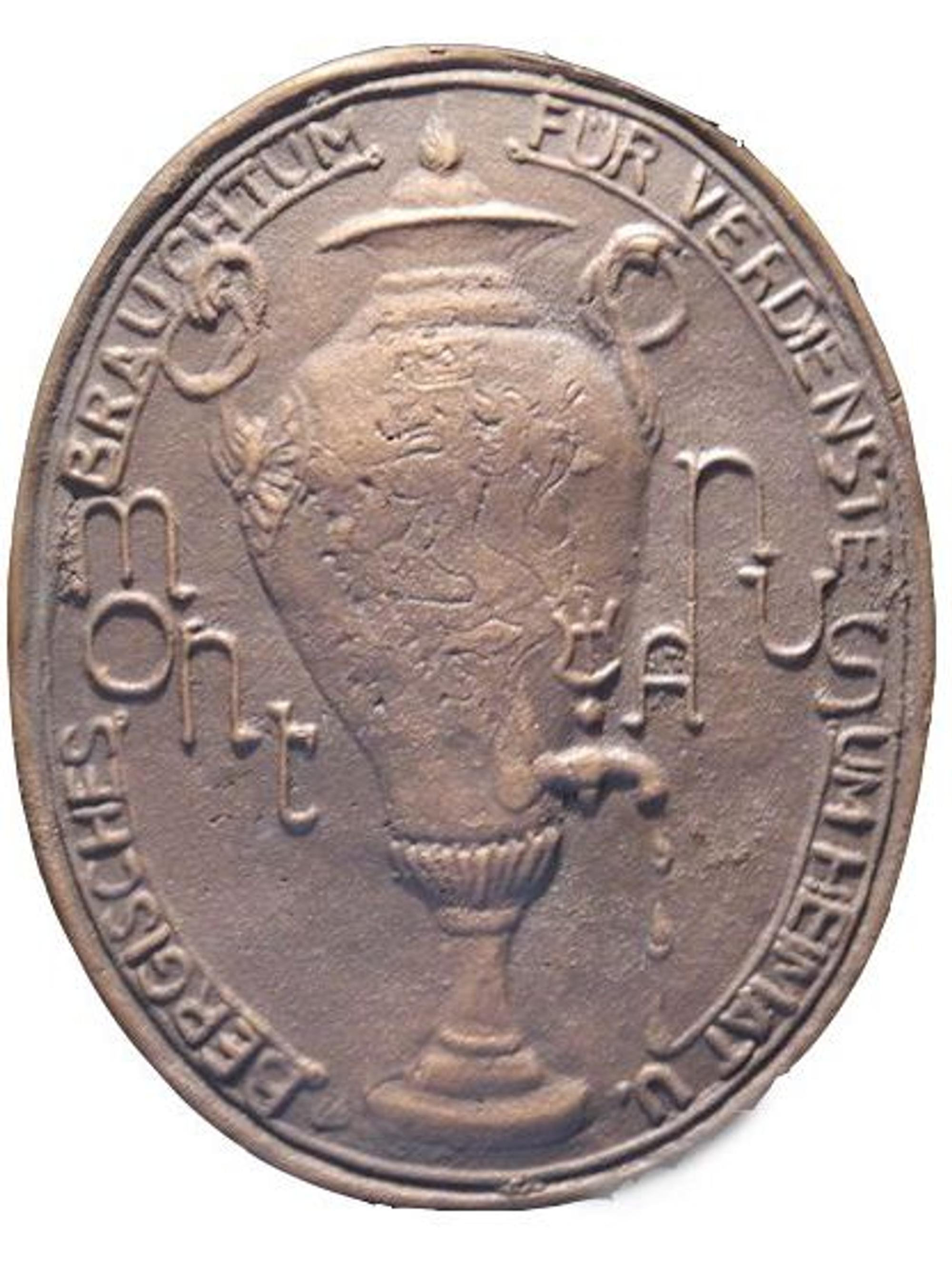 Auf einer Plakette mit Dröppelminna steht die Umschrift „Für Verdienste um Heimat und Bergisches Brauchtum“.