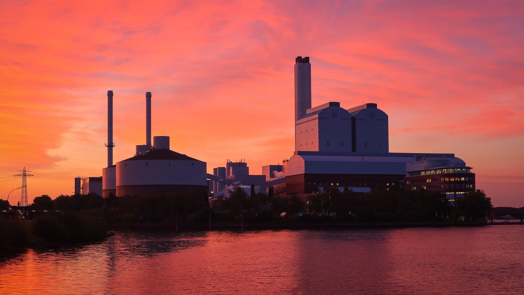 Das Heizkraftwerk Tiefstack in Hamburg im rötlichen Schimmer der Dämmerung.
