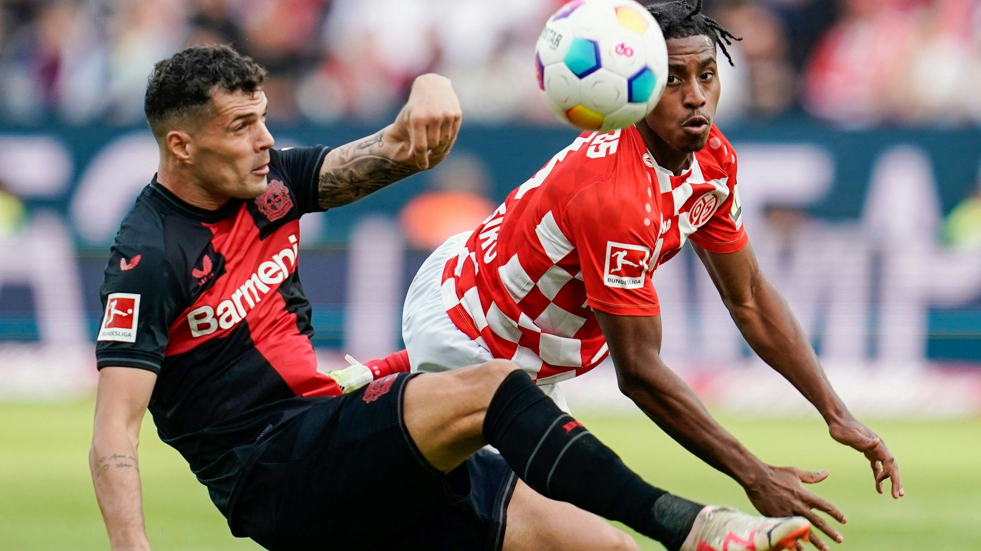 Leverkusens Granit Xhaka (l) und Leandro Barreiro von Mainz kämpfen um den Ball.
