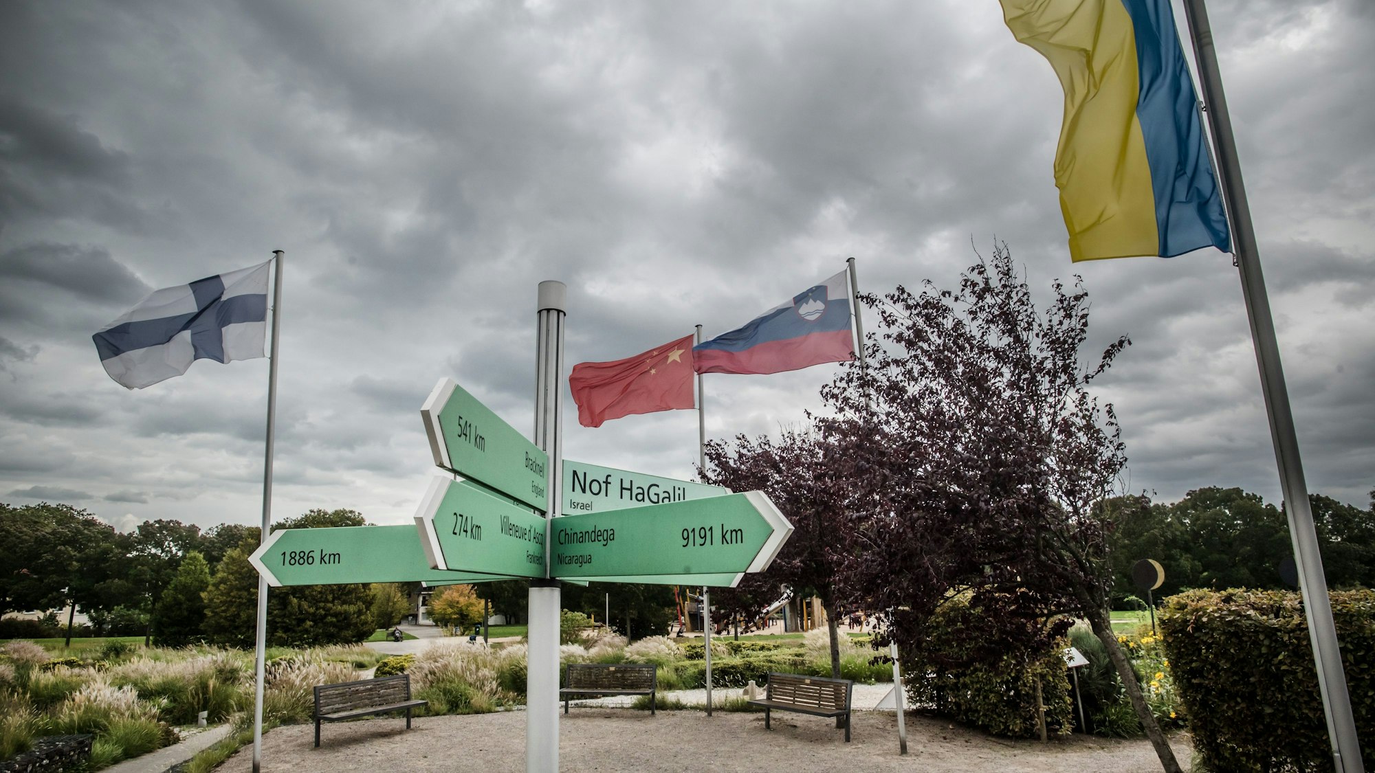 Im Neulandpark stehen Flaggenmaste in einem Kreis, daran sind Landesflaggen für die Partnerstädte gehisst. Foto: Ralf Krieger