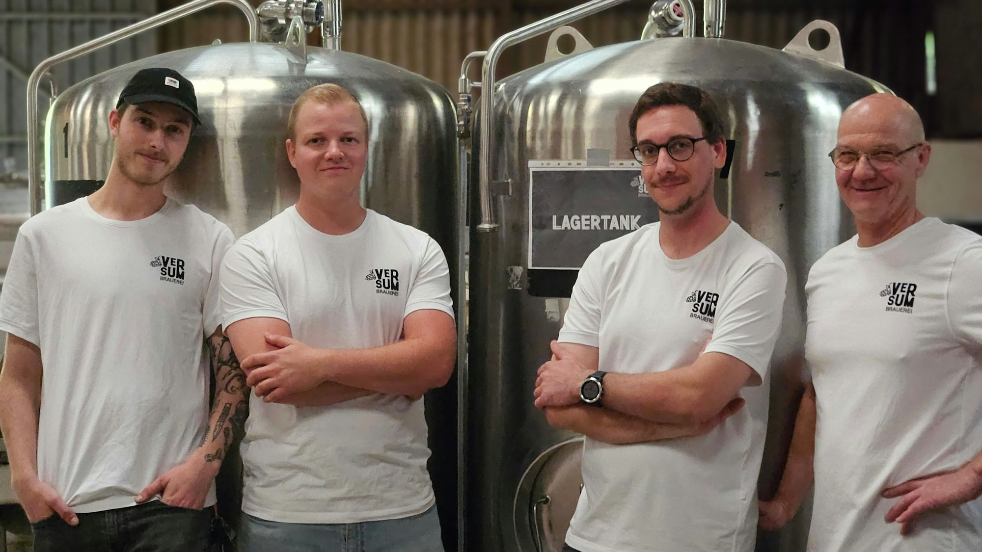 Till und Jonas Verse, Jan Summa und Peter Verse vor den Lagertanks der Brauerei.