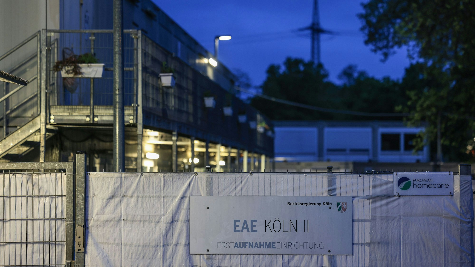 Wohncontainer der kommunalen Erstaufnahmeeinrichtung in Köln II sind am Morgen beleuchtet. Bund und Länder suchen bei einem Spitzentreffen in Berlin nach Lösungen im Streit über die Aufteilung der Kosten für die Versorgung von Flüchtlingen. (Zu dpa: «Gipfel berät über Flüchtlingsfrage») +++ dpa-Bildfunk +++