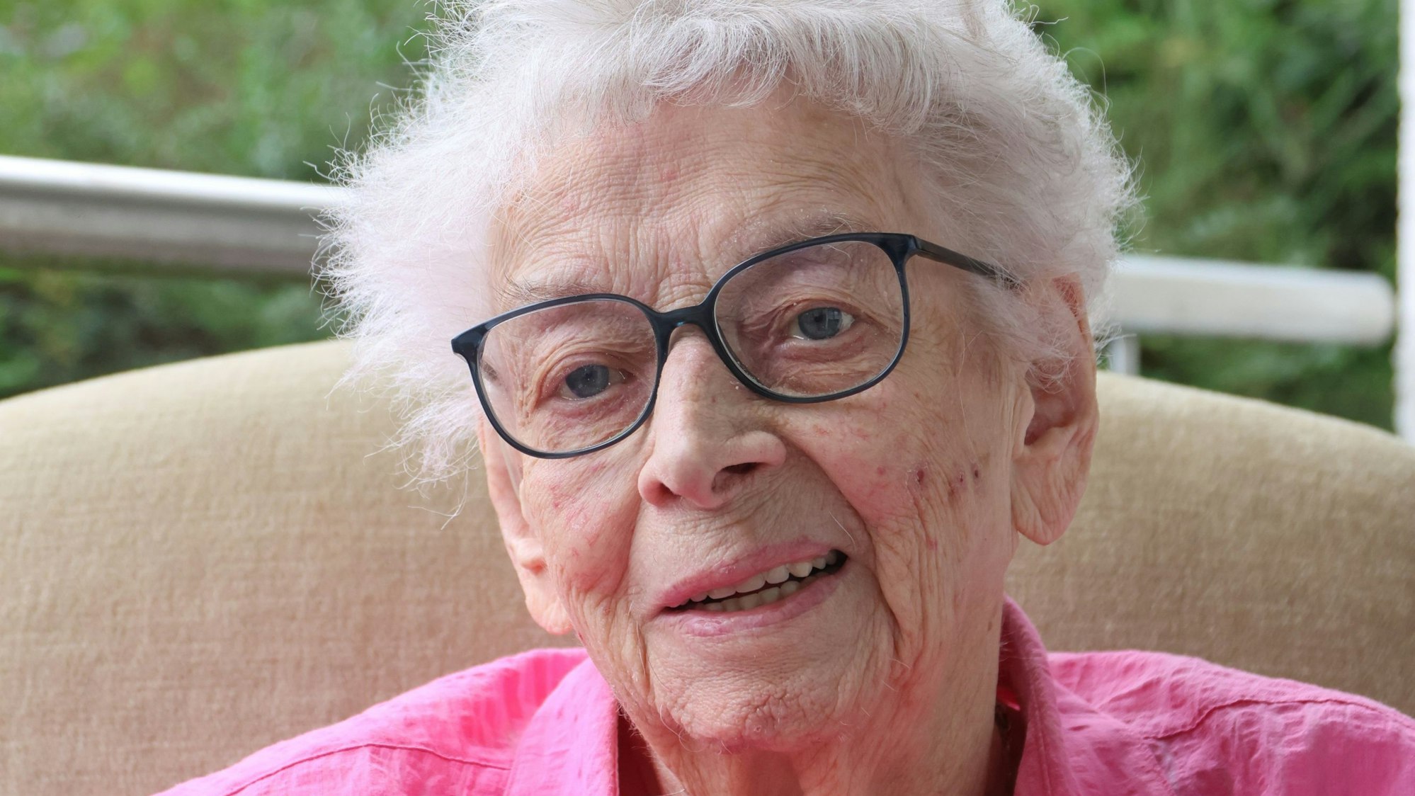 Porträt von Lucia Puhl, die eine pinke Bluse trägt.