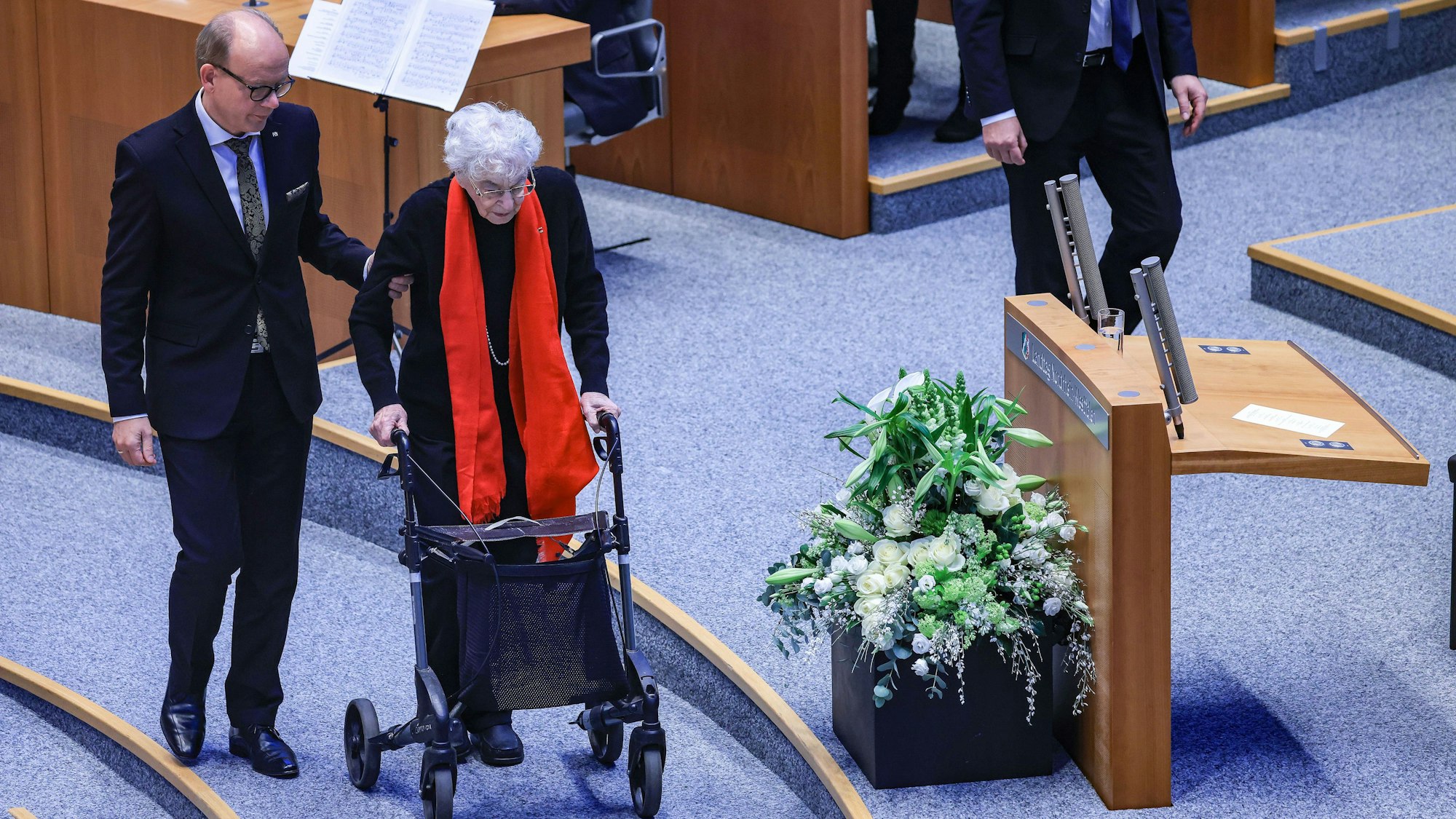 Andre Kuper (l, CDU), Landtagspräsident, begleitet Ruth Weiss (r), Journalistin und Schriftstellerin, während einer Gedenkstunde für die Opfer des Nationalsozialismus im Landtag von Nordrhein-Westfalen zum Rednerpult.