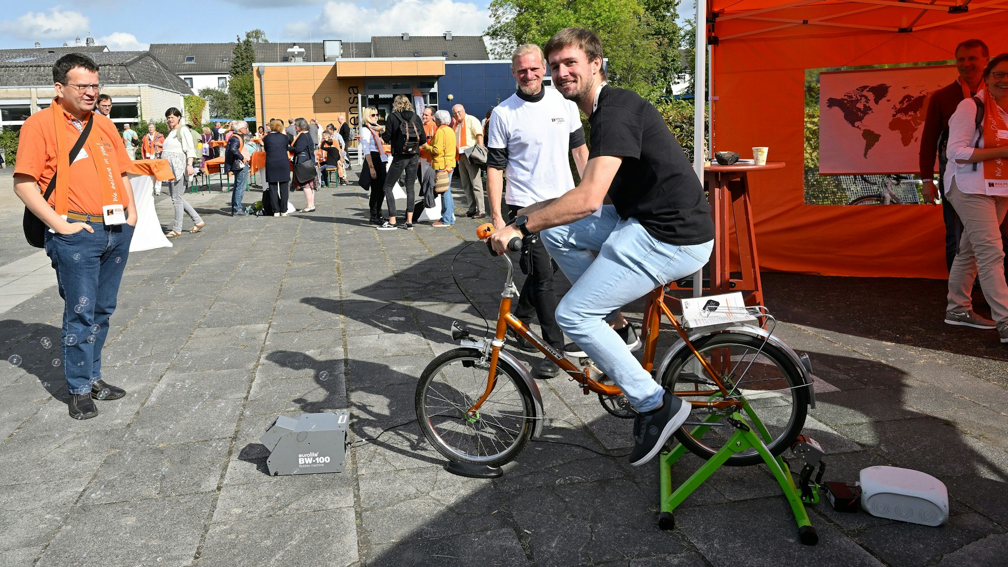 Ein Mann sitzt auf einem Fahrrad und treibt einen Dynamo an.