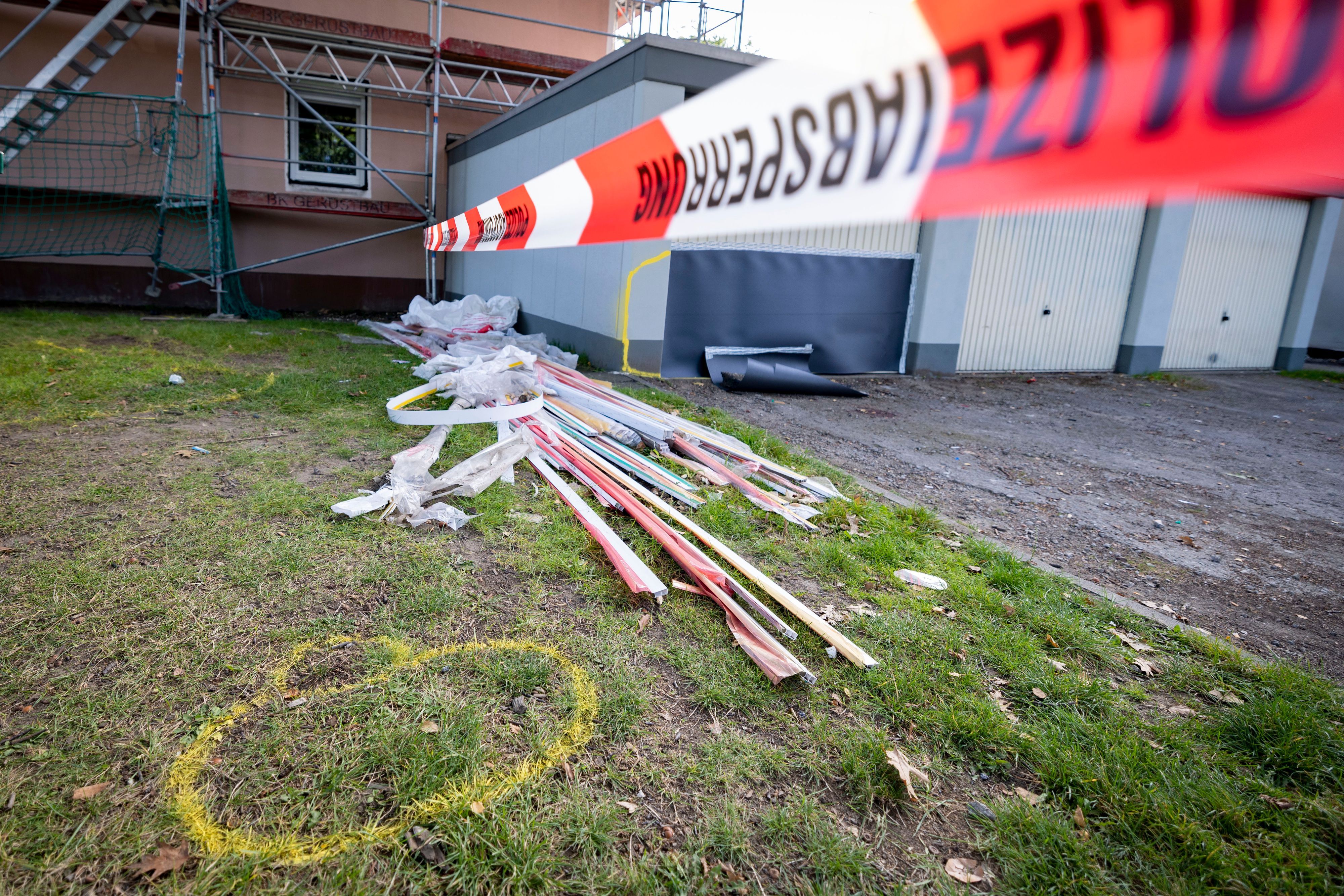 Flatterband der Polizei sperrt einen Tag nach einer Attacke eines 25 Jahre alten Mannes auf seine 19 Jahre alte Ehefrau und seinen 17 Monate alten Sohn den Tatort ab. Gelbe Markierungen zeigen Fundorte von Beweisstücken an. Die Frau verstarb, der Sohn schwebt weiterhin in Lebensgefahr. Der 25-jährige Fahrer wurde festgenommen. Eine Mordkommission ermittelt.